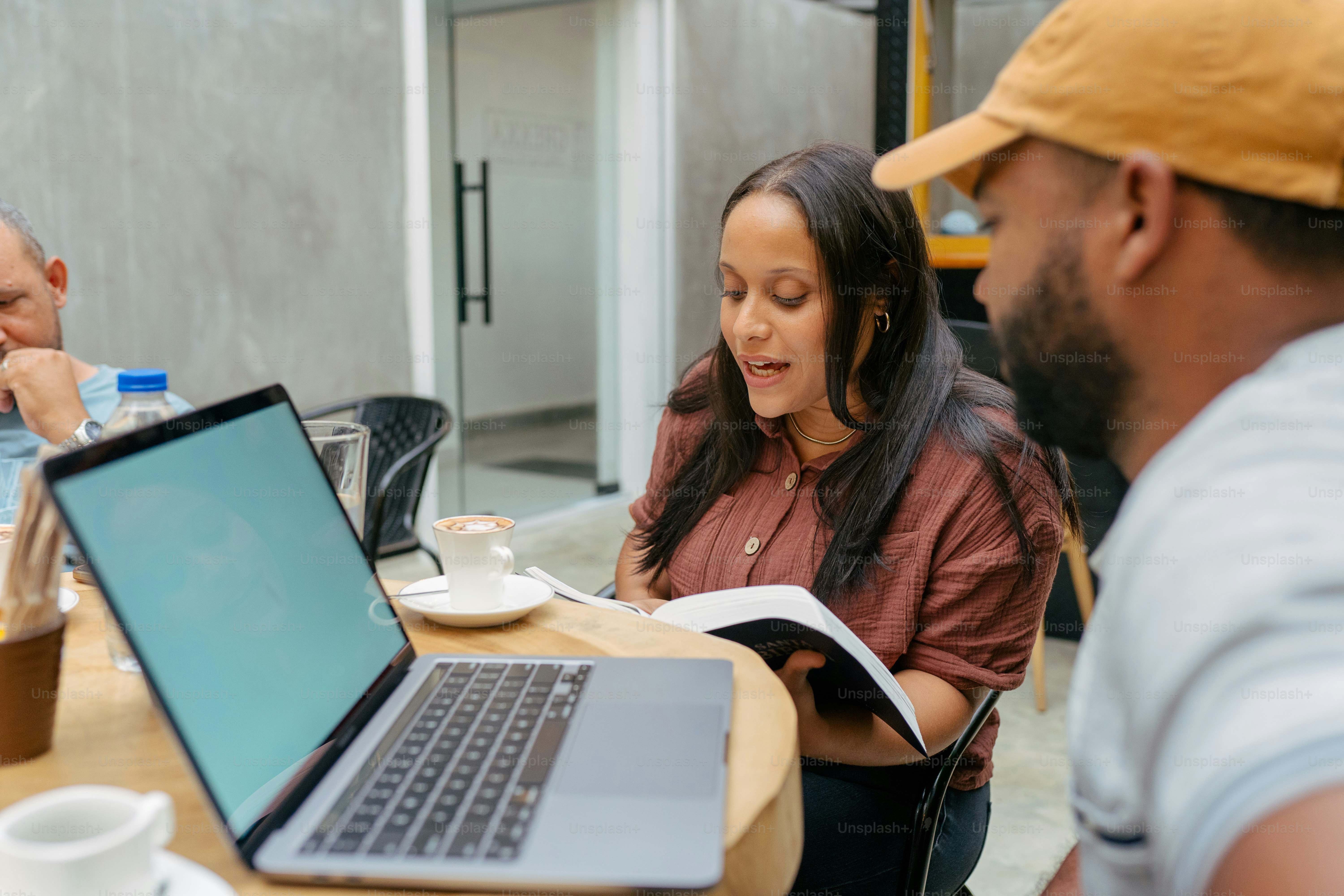 a man and a woman sitting at a table with a laptop