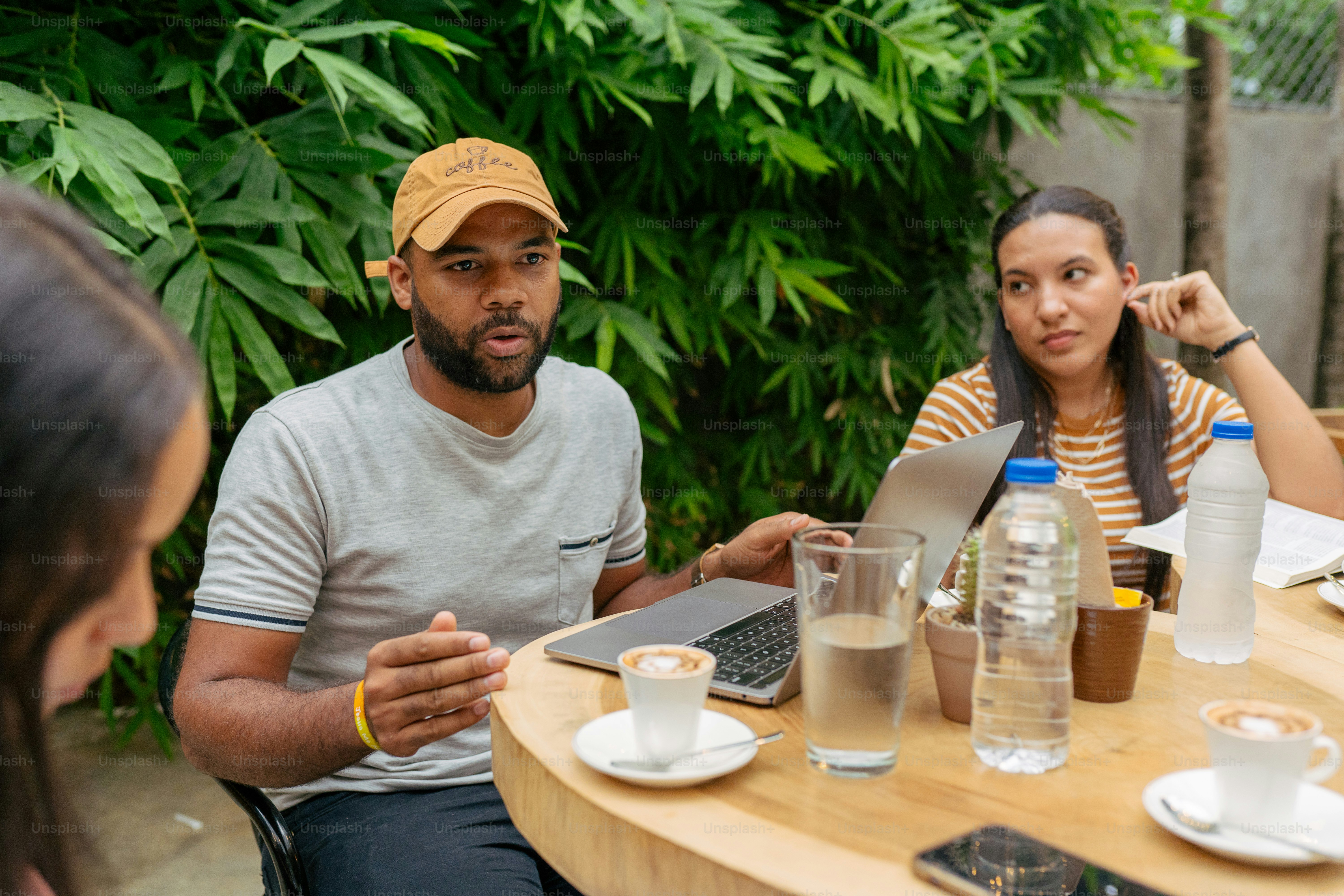a man and woman sitting at a table with a laptop