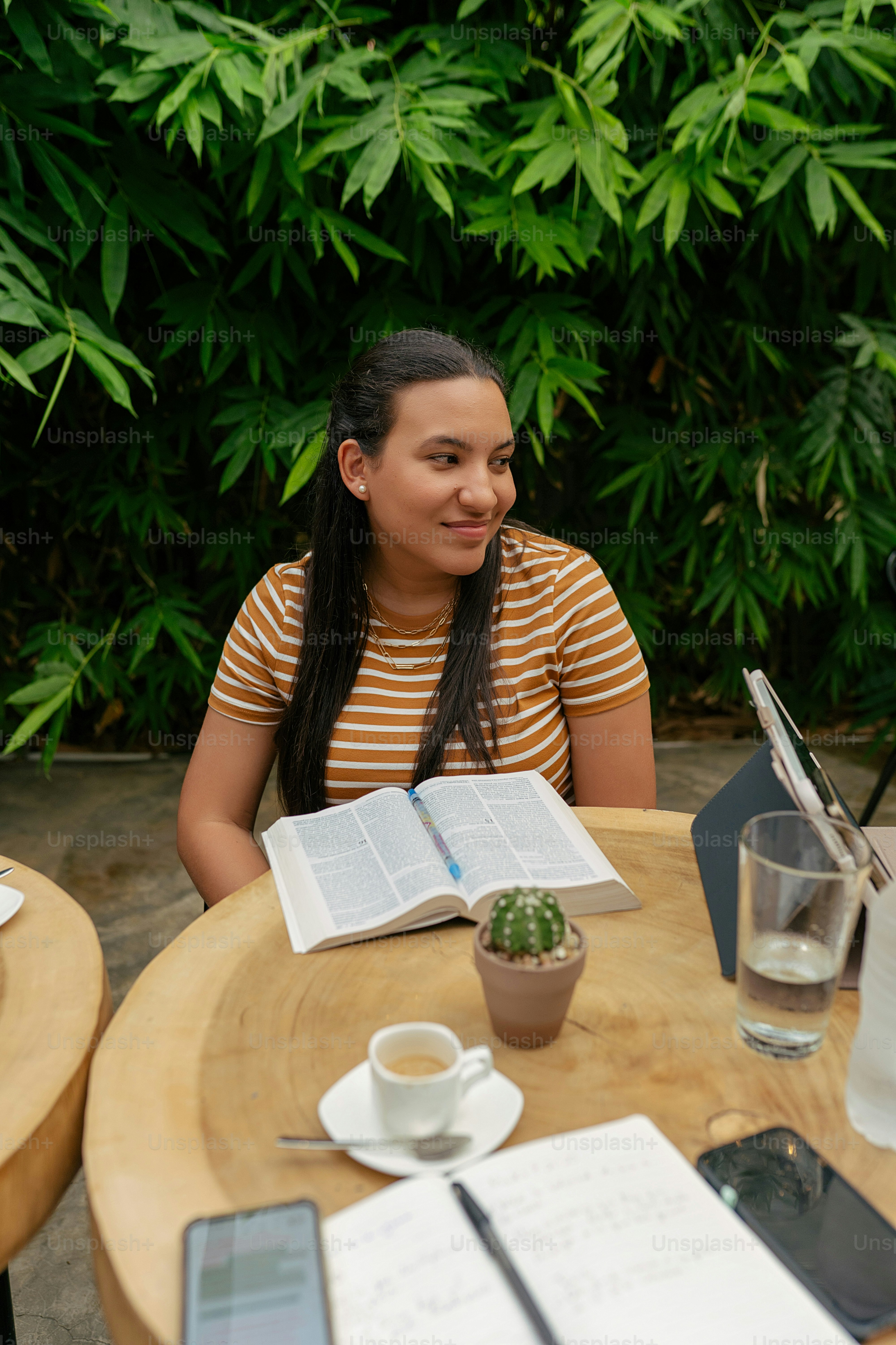 a woman sitting at a table with an open book