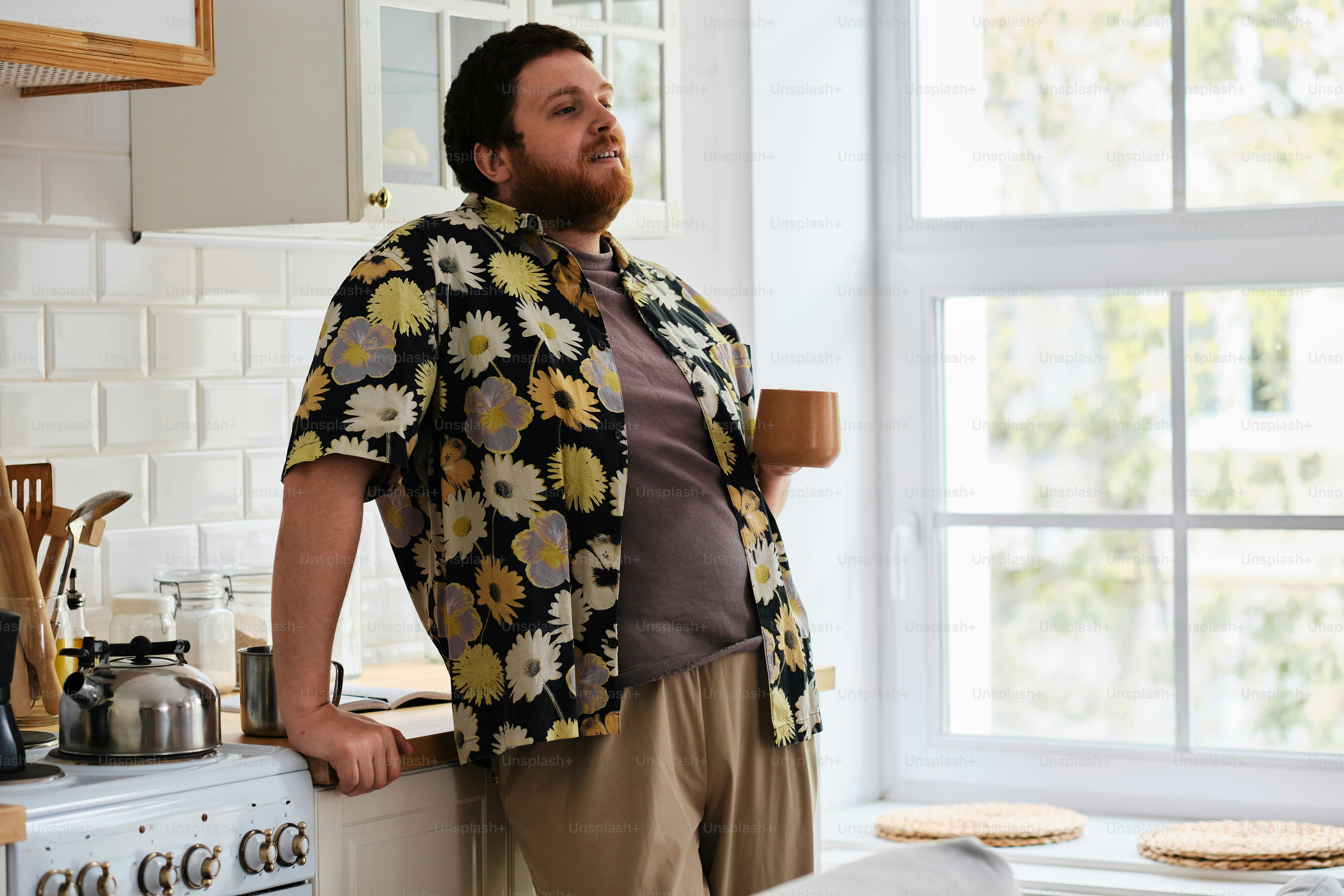 Ein Mann, der in einer Küche neben einem Fenster steht