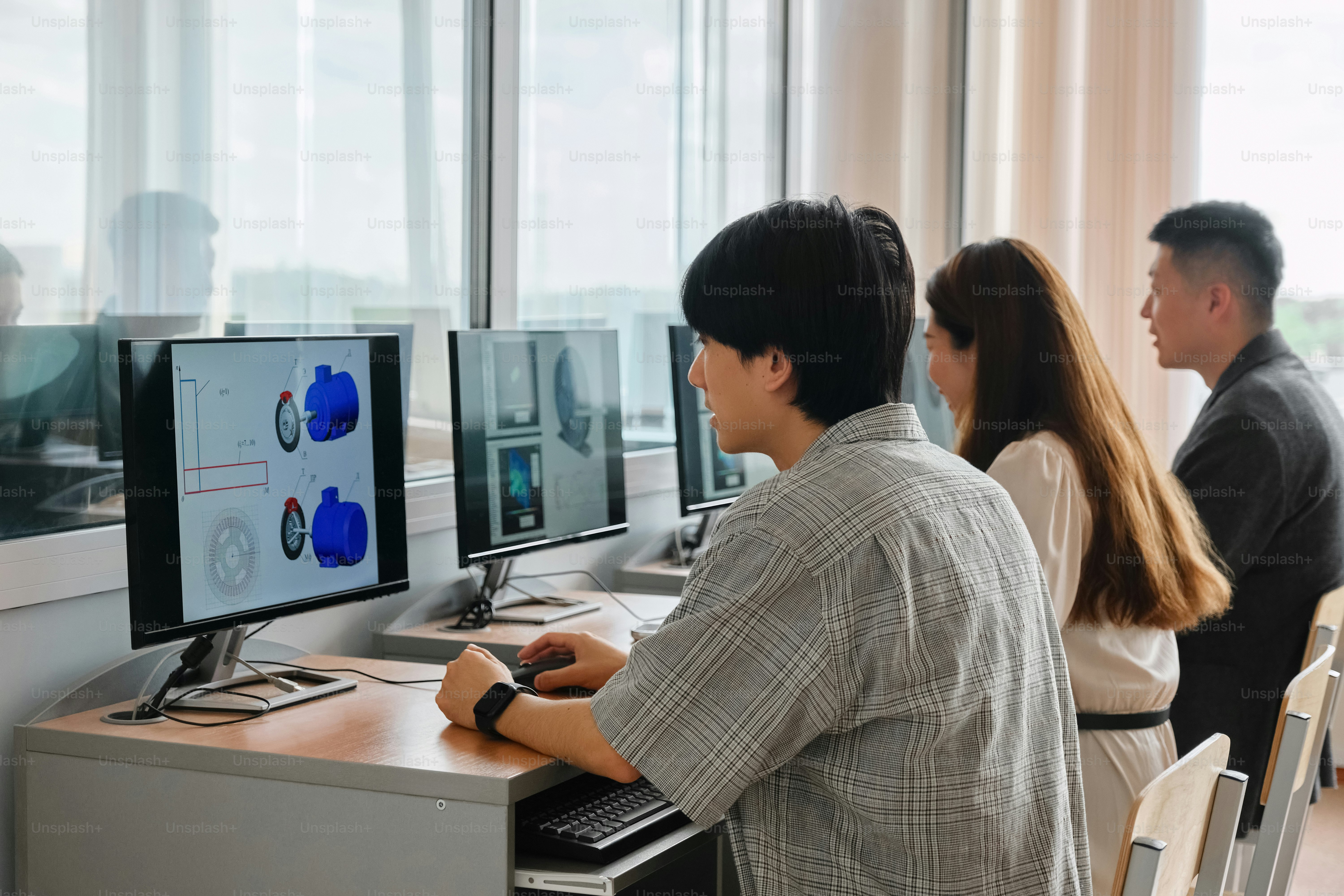 un gruppo di persone sedute davanti ai monitor dei computer