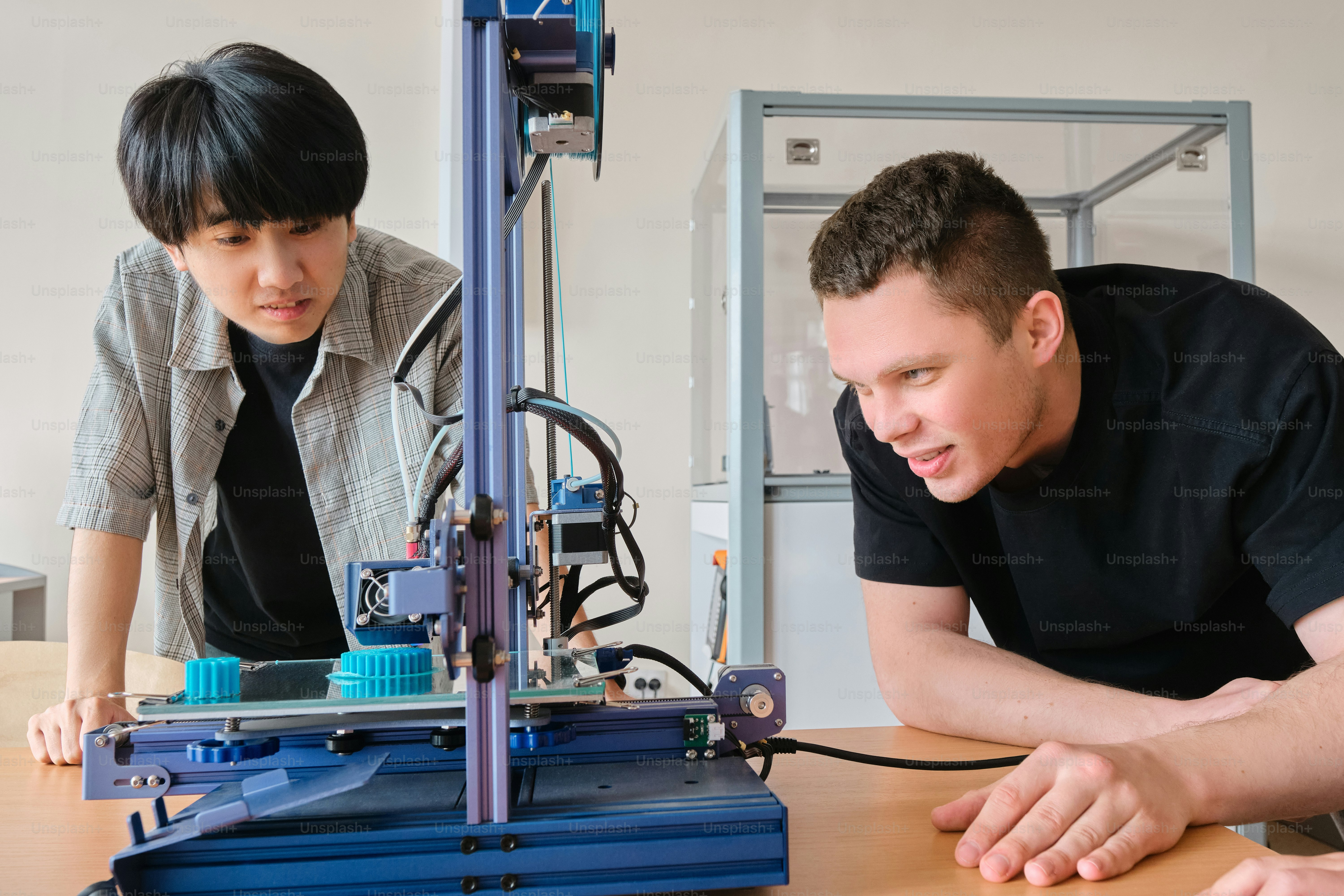 a man and a woman looking at a 3d printer