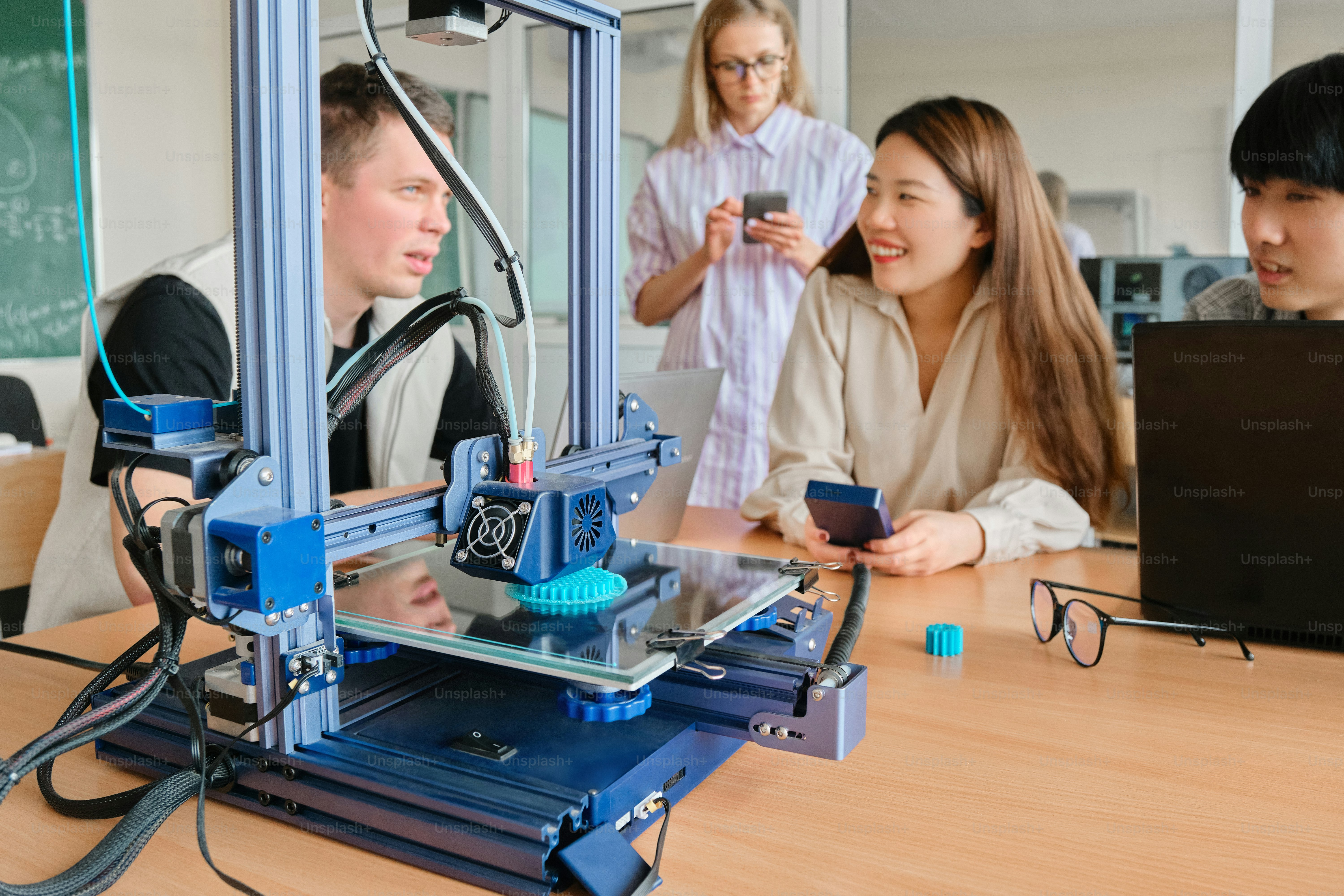 a group of people working on a 3d printer
