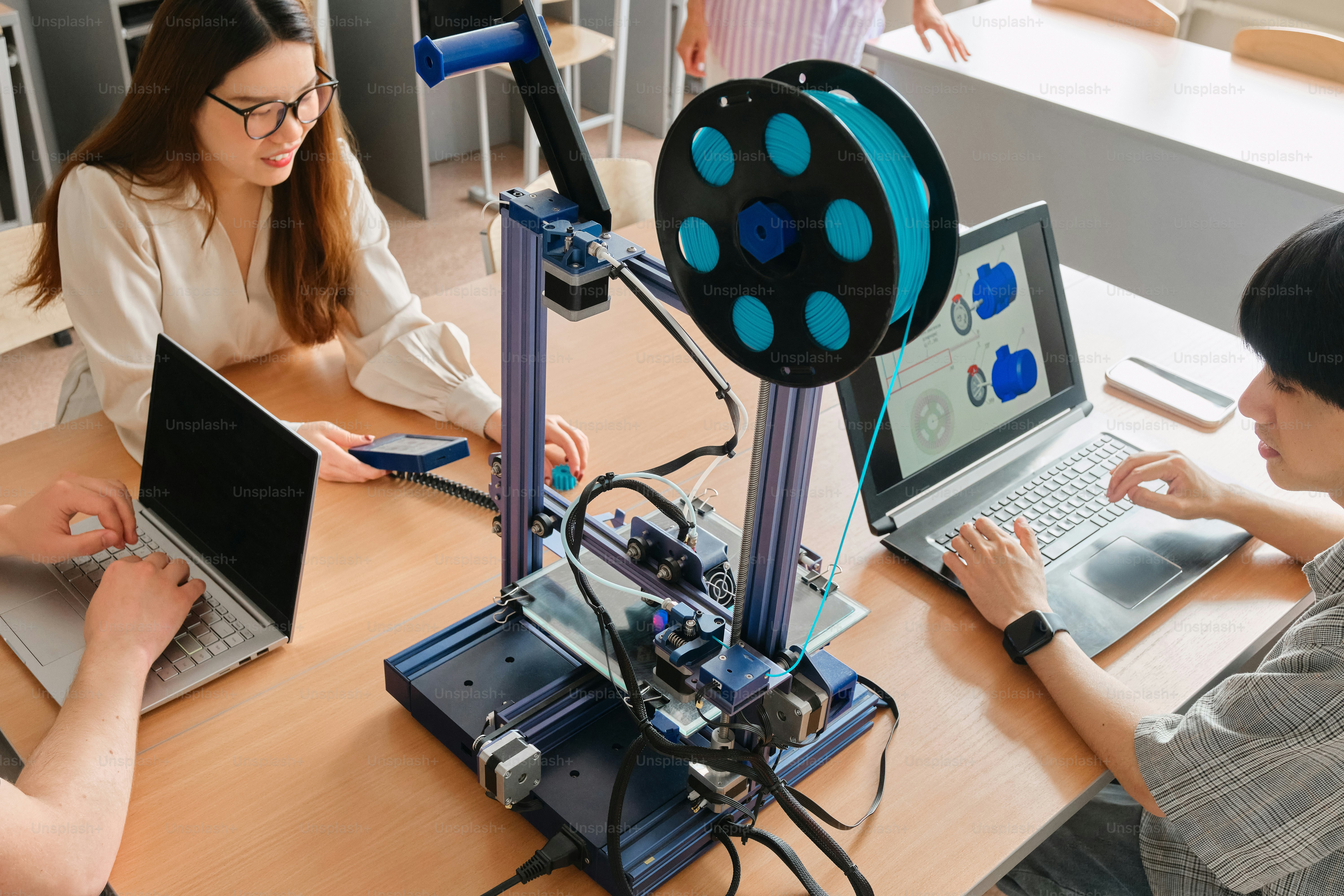 a couple of people sitting at a table with laptops