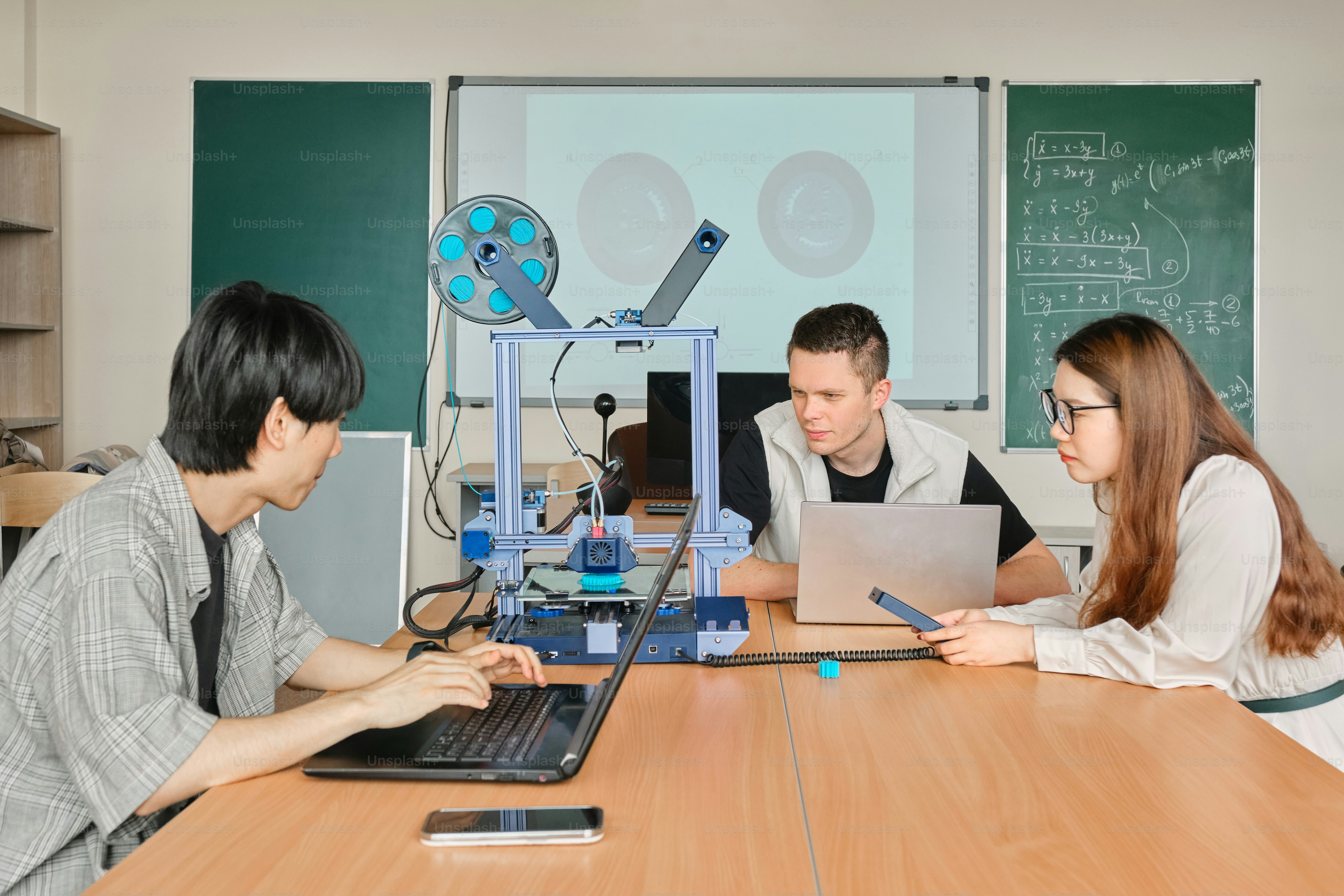 a group of people sitting around a table with a laptop