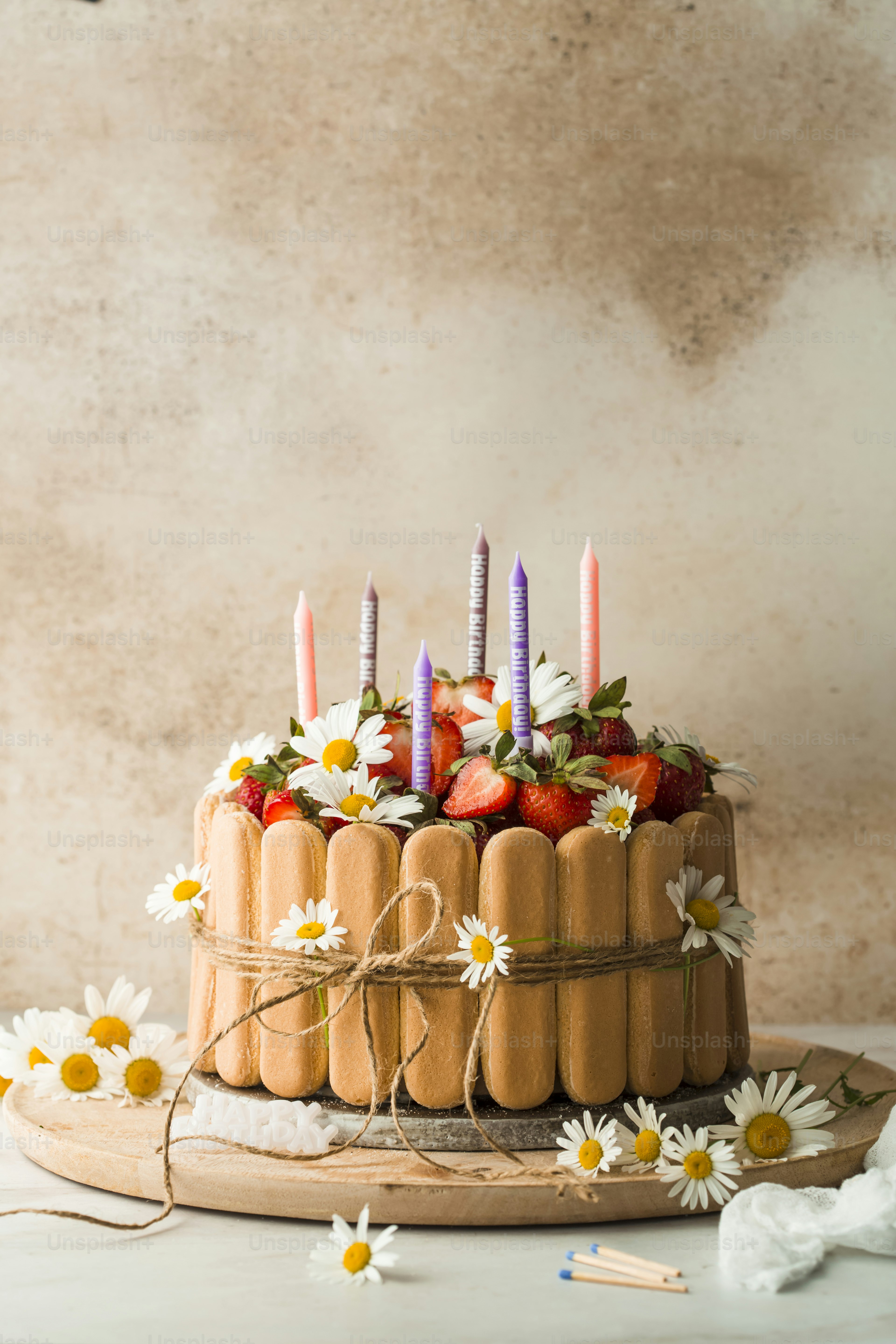 kue dengan lilin dan bunga di atas meja