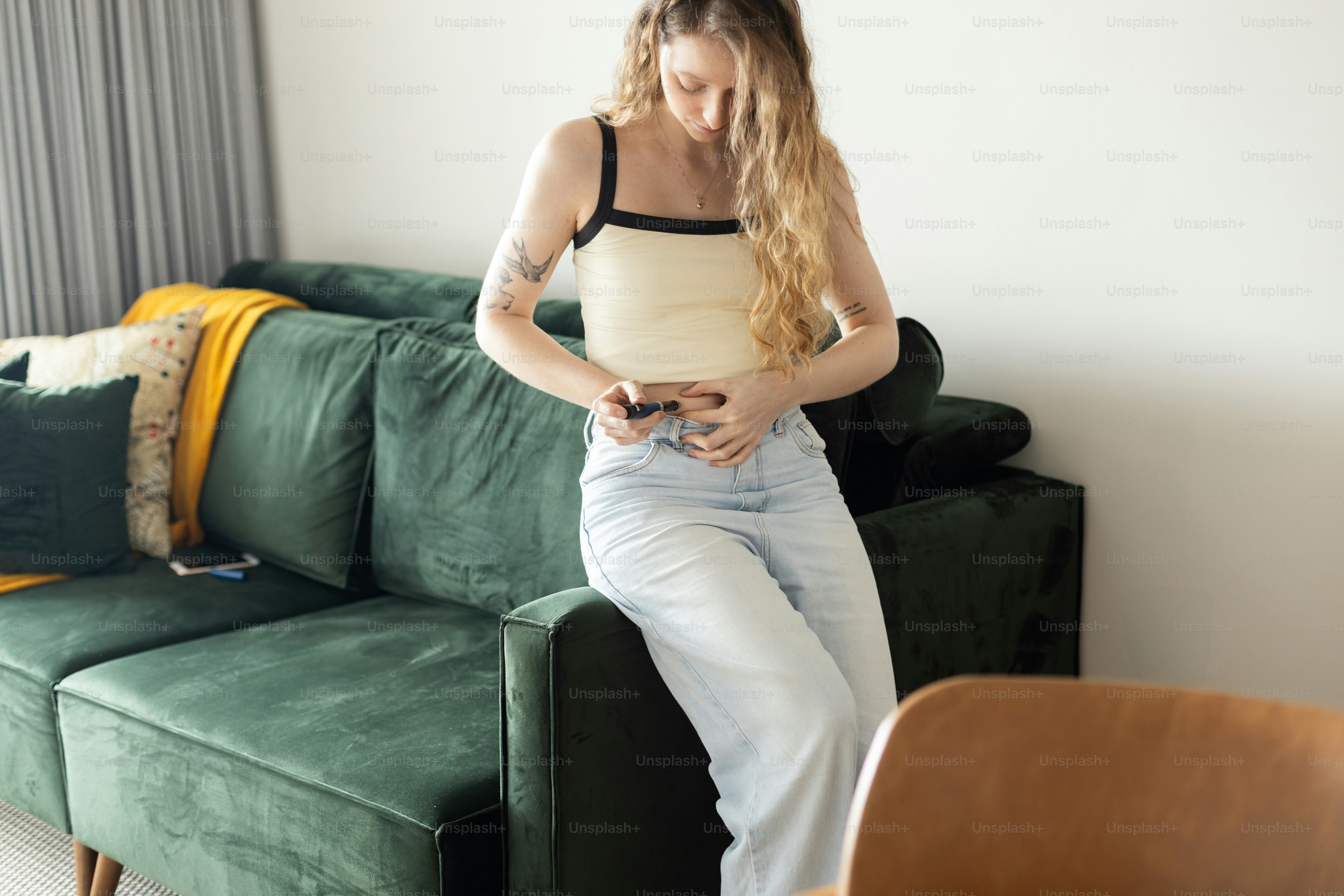 a woman sitting on a couch looking at her cell phone