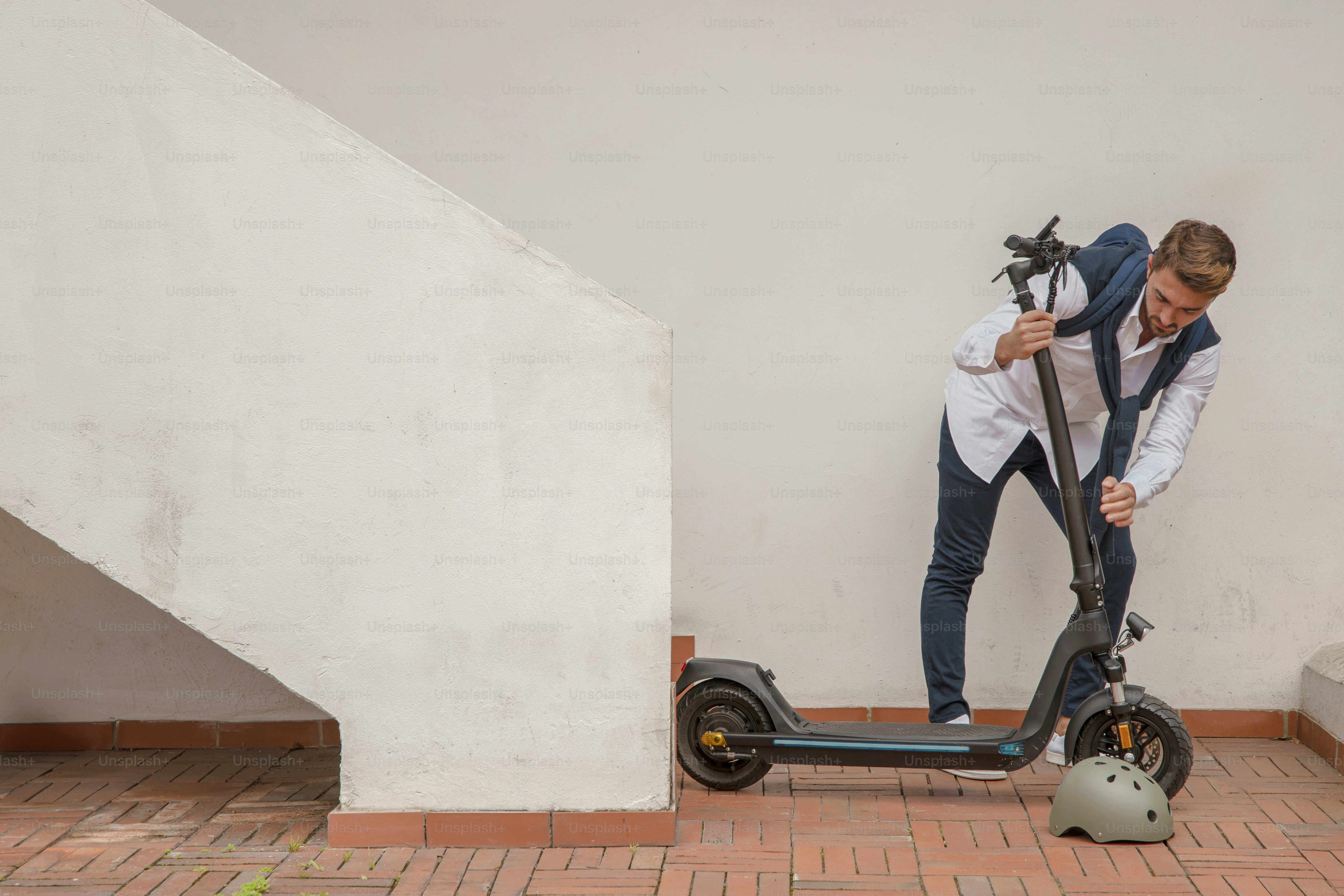 a man standing next to a scooter on a brick floor