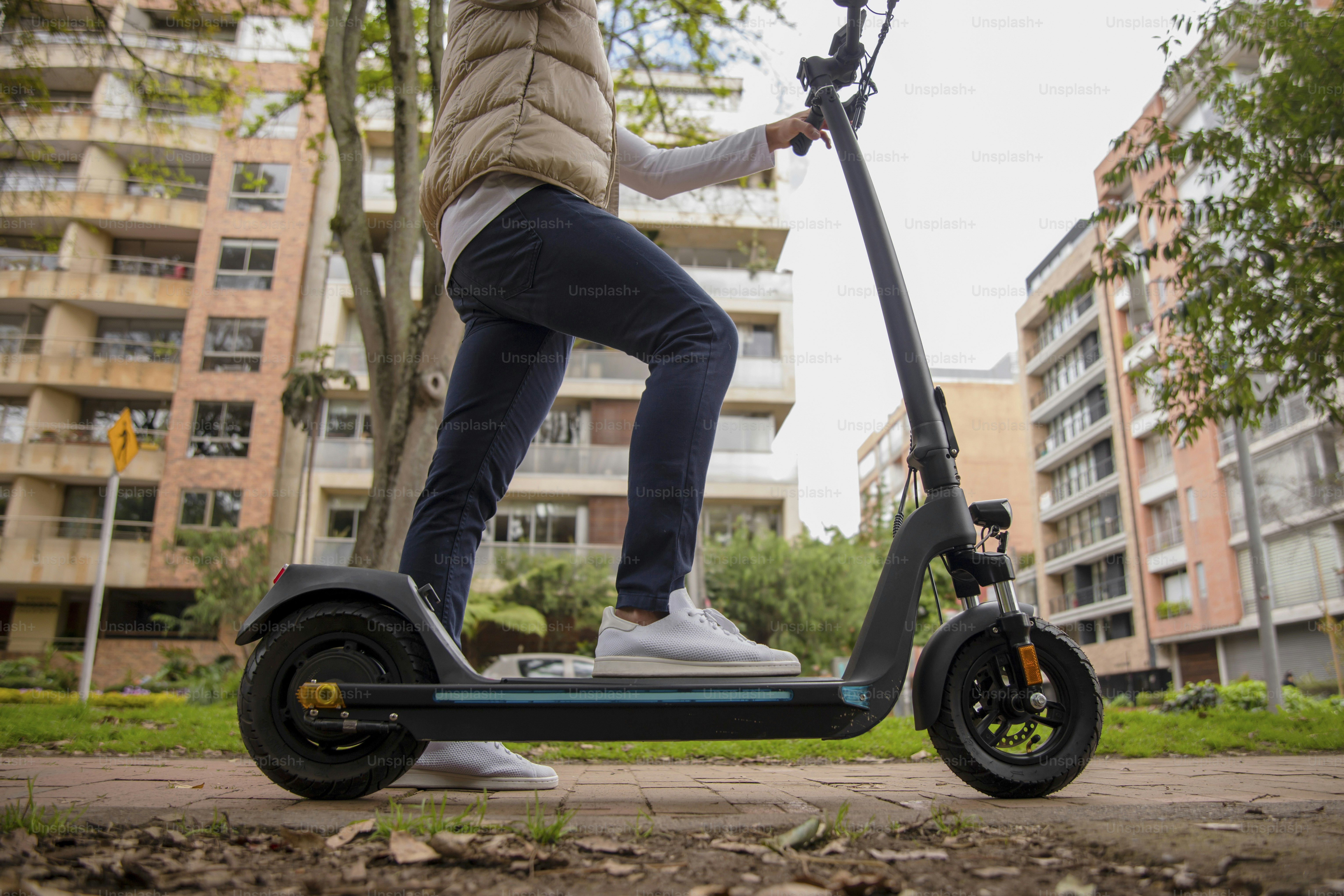 una persona montando un scooter en una calle de la ciudad