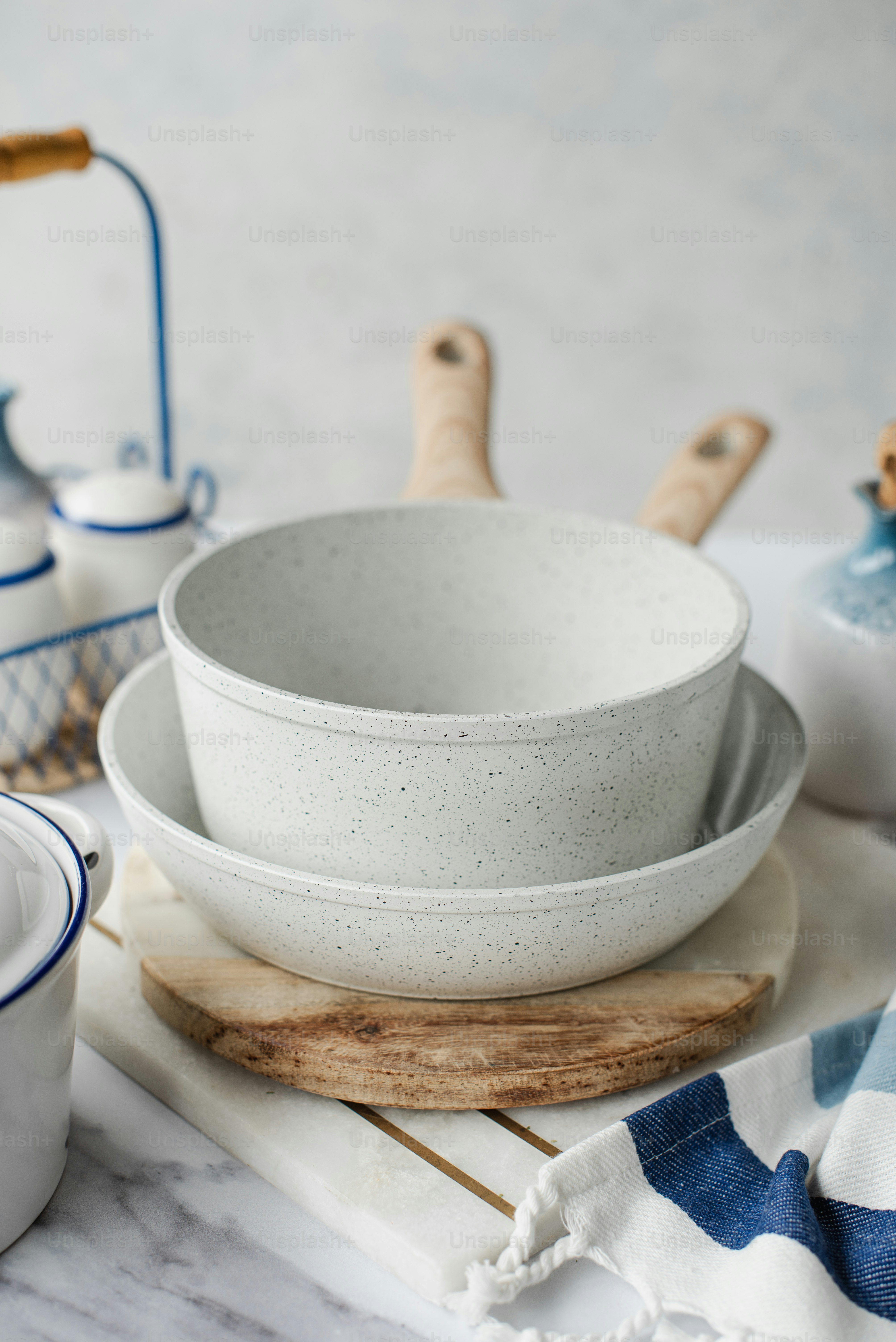 a table topped with white bowls and wooden spoons