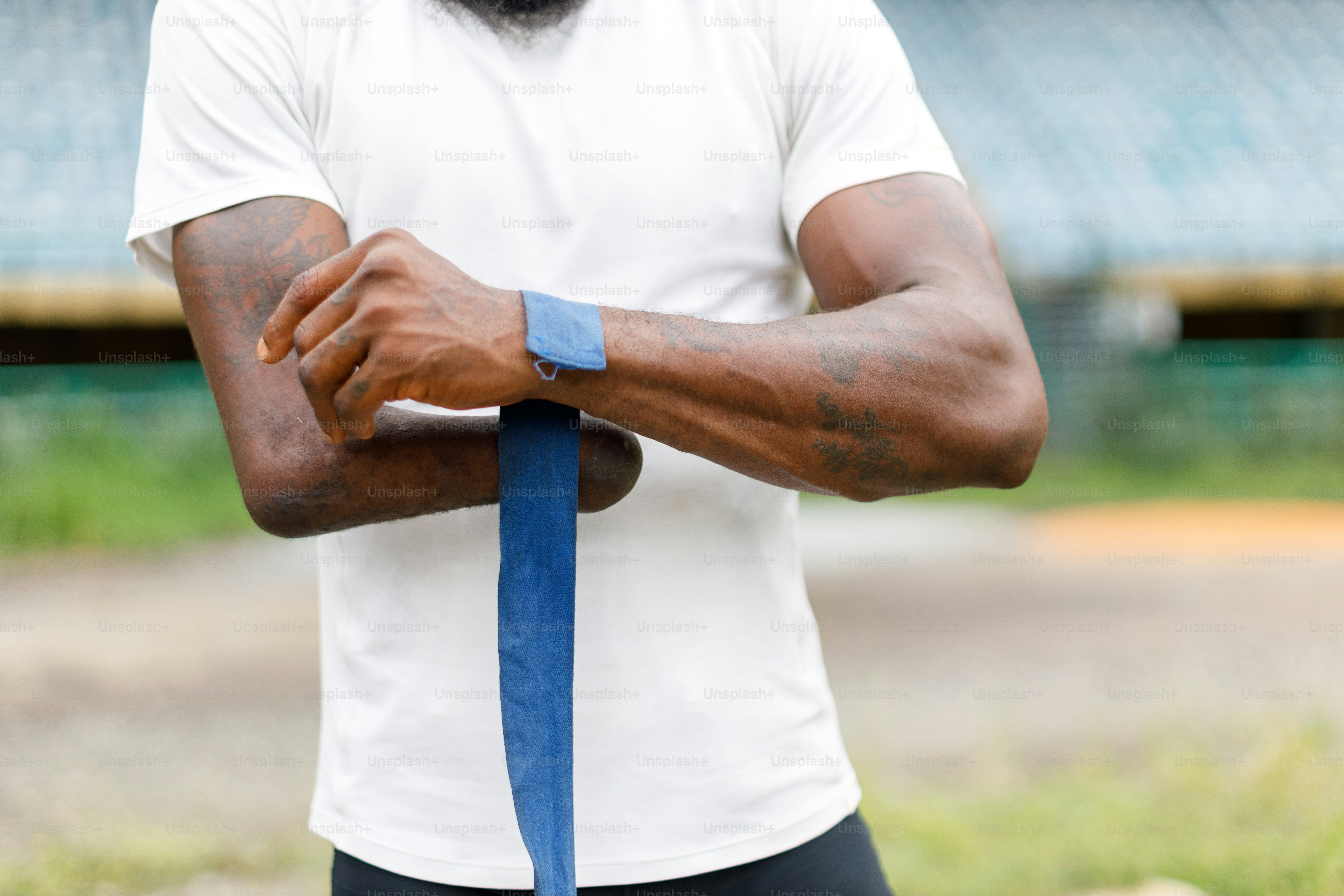 Ein Mann mit Bart und weißem Hemd hält eine blaue Krawatte in der Hand