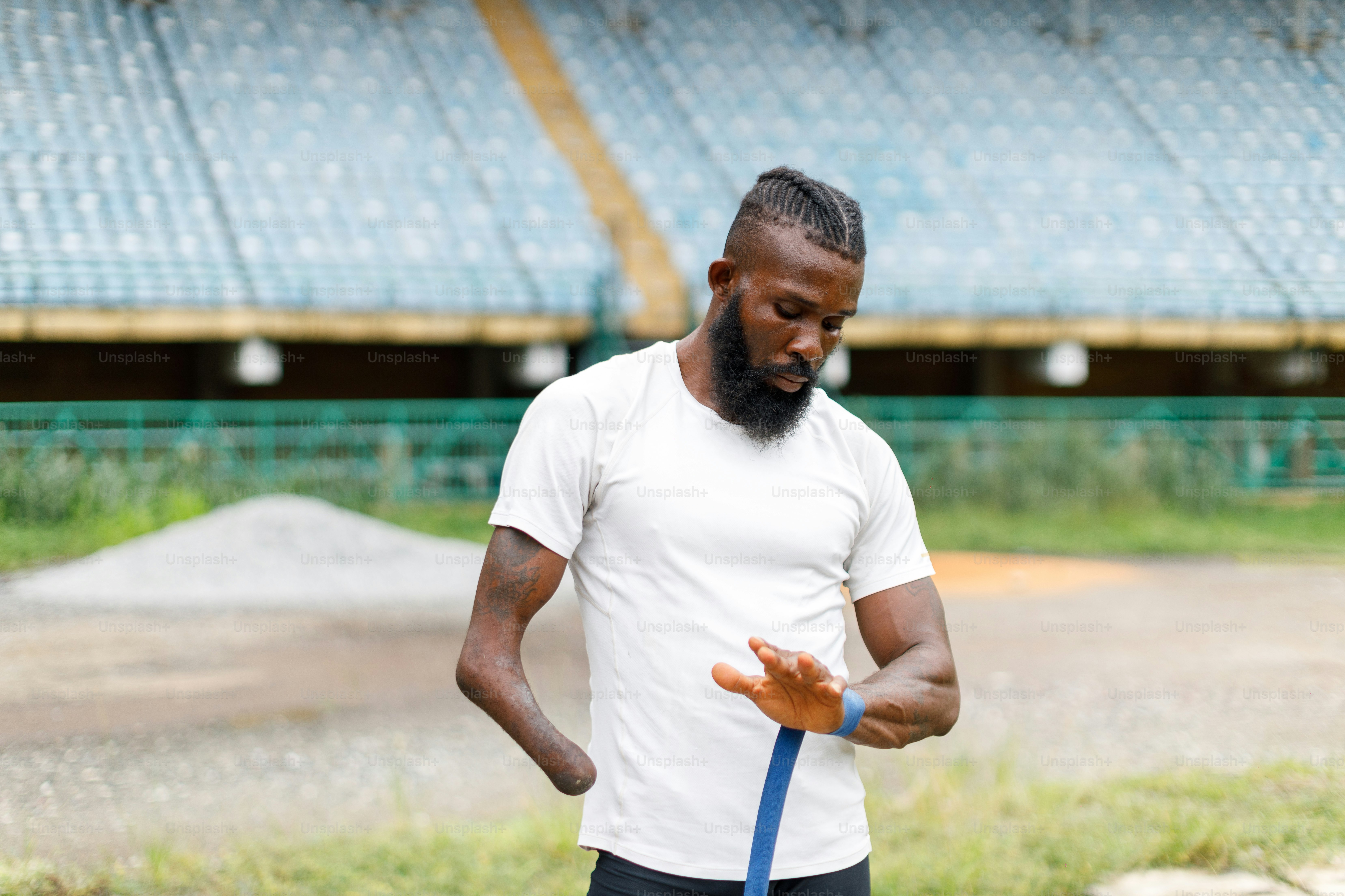 Ein Mann mit blauer Leine vor einem Stadion
