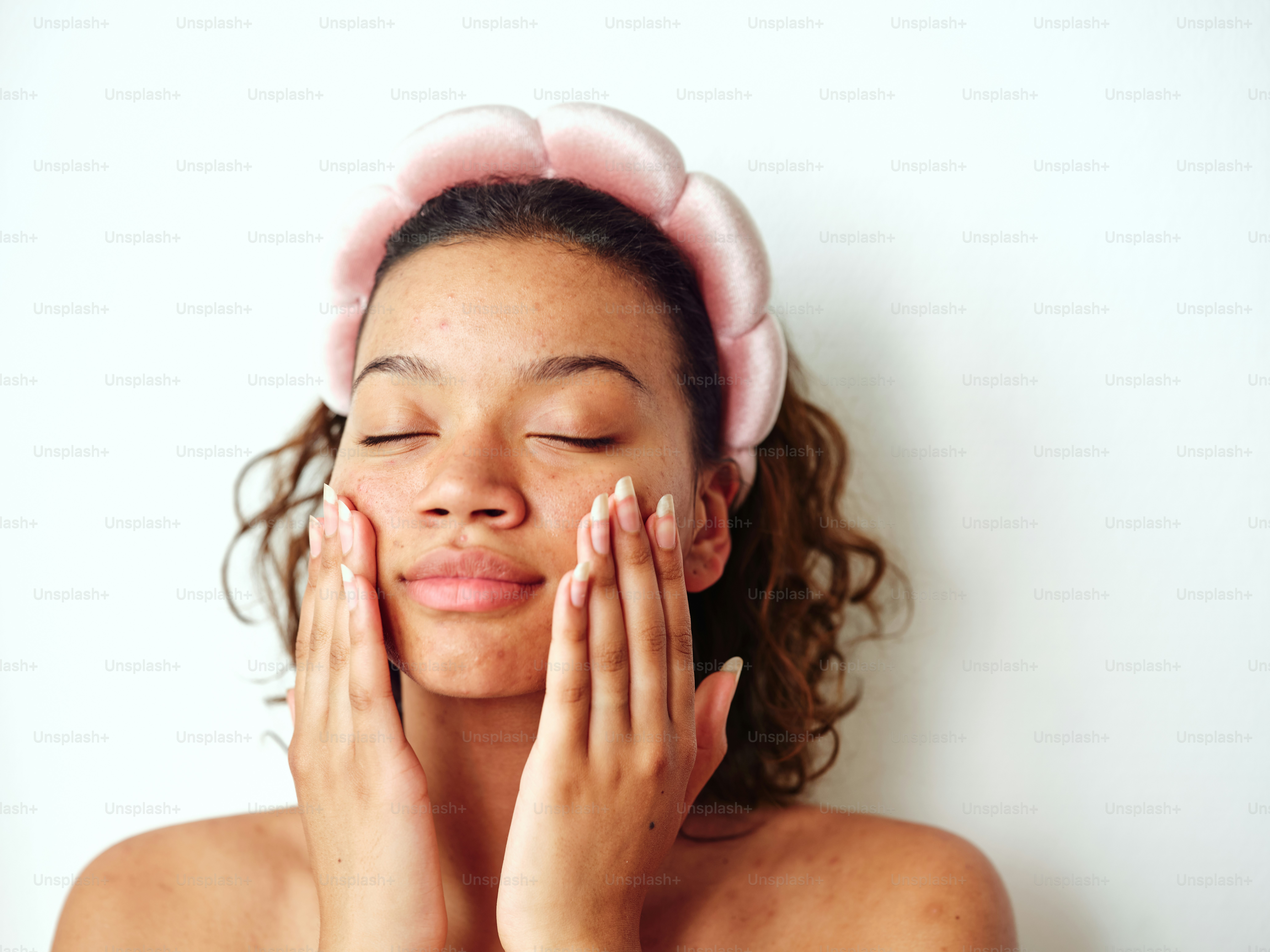 a woman with a towel on her head holding her hands to her face