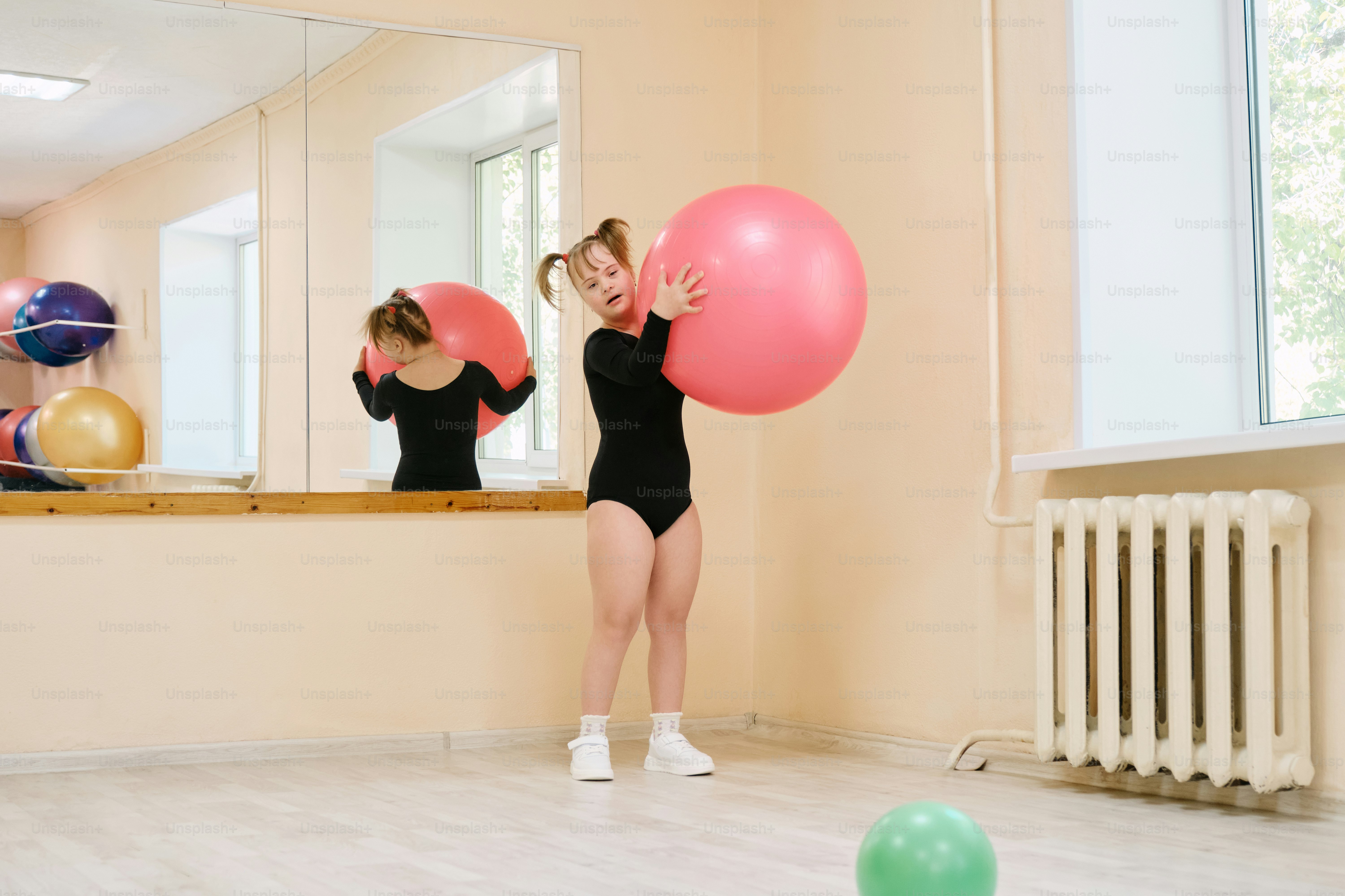 una donna in un body nero che tiene palloncini rosa