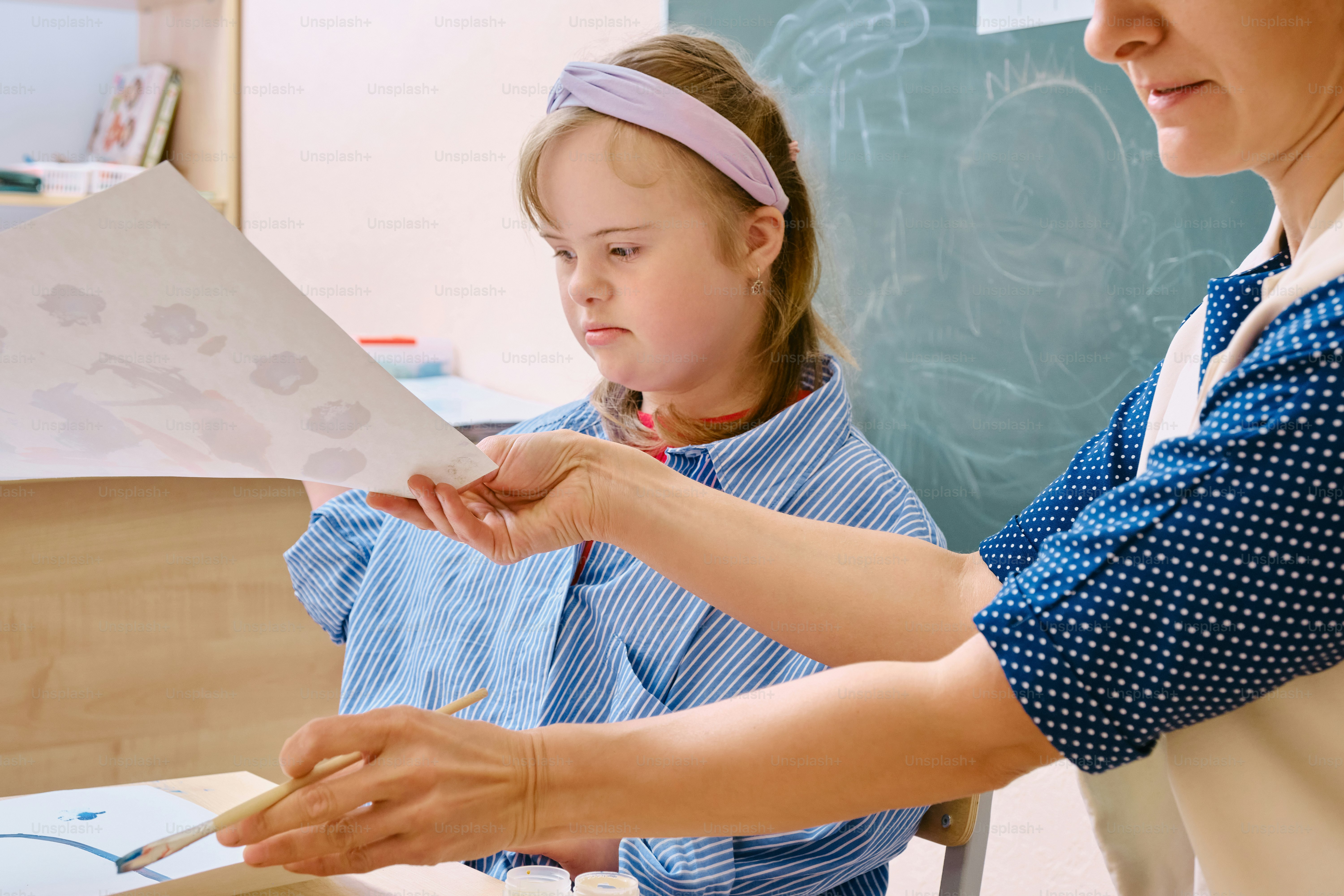 a woman teaching a girl how to paint