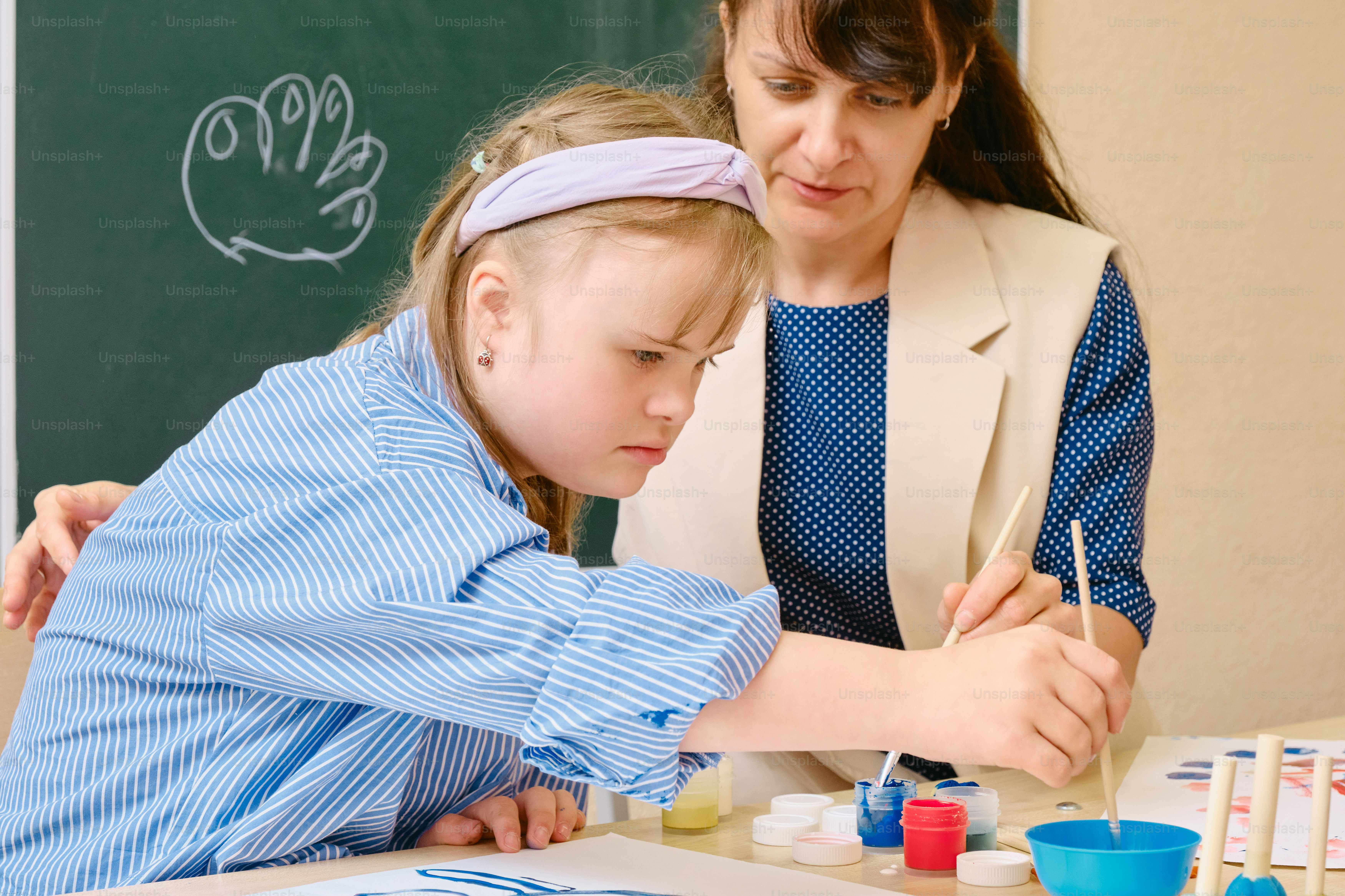 una donna e una bambina che dipingono su un tavolo