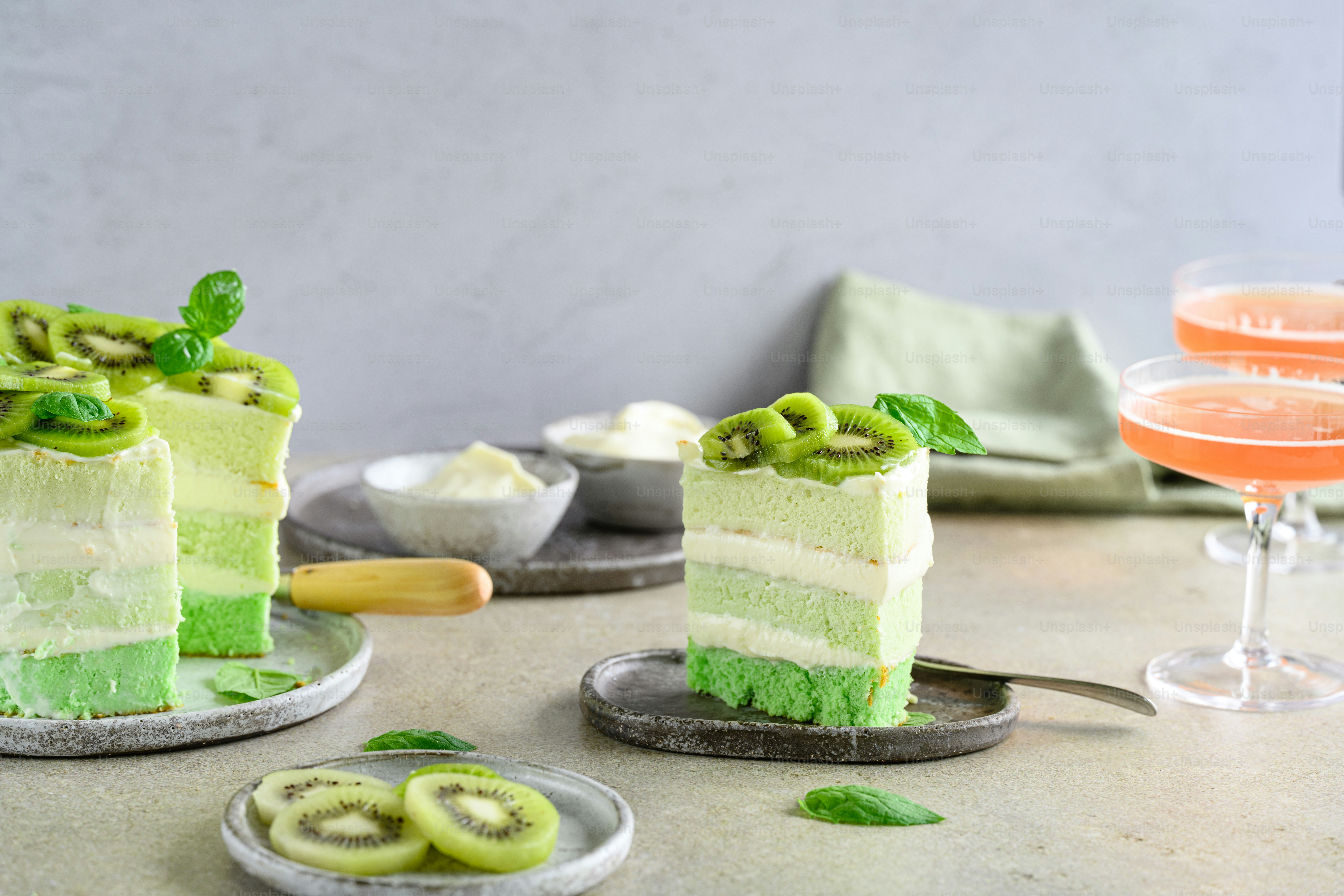 a table topped with two slices of cake next to a glass of wine