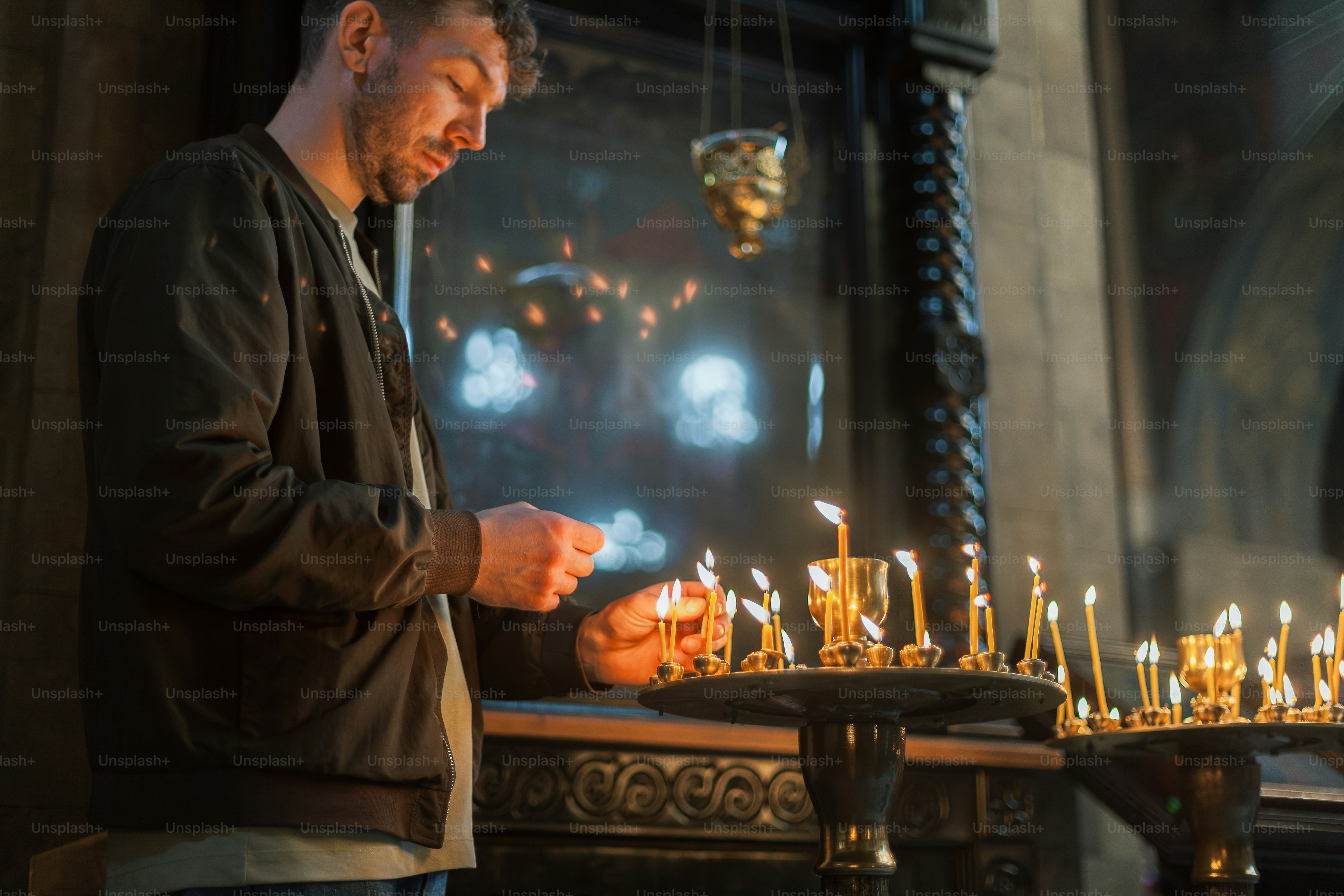 a man standing in front of a table filled with candles