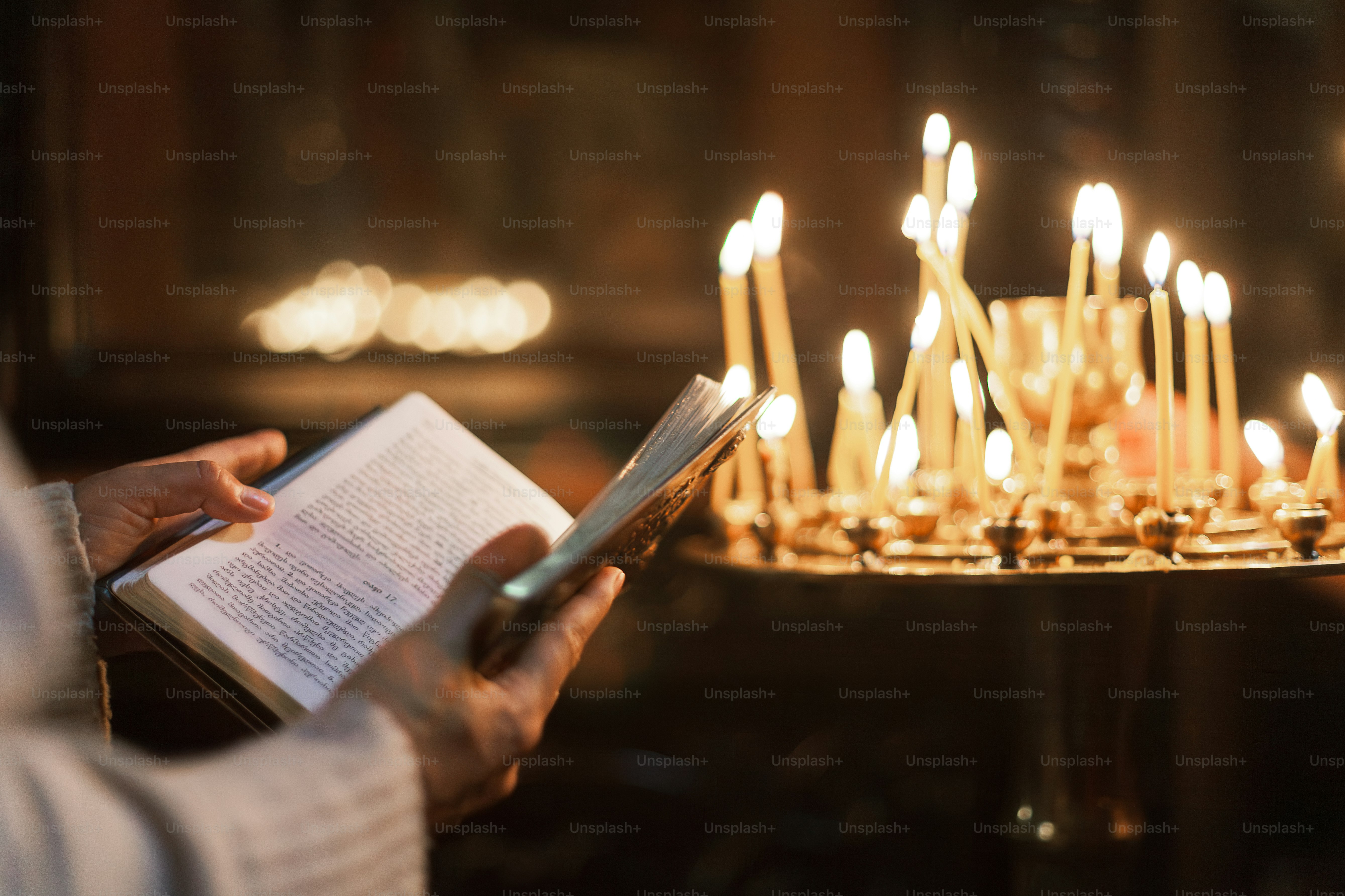 uma pessoa está lendo um livro na frente de velas