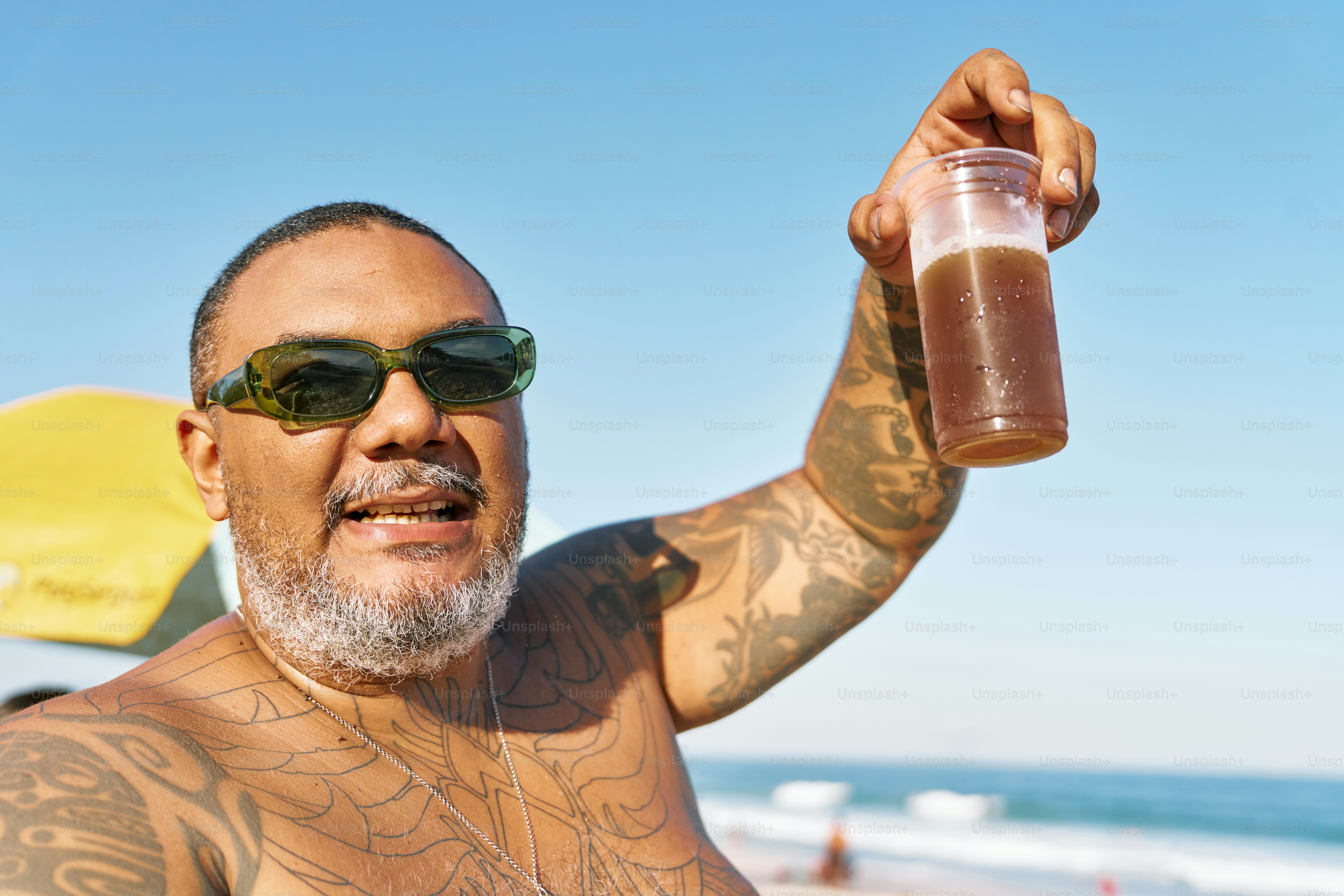a man with a tattooed arm holding a drink
