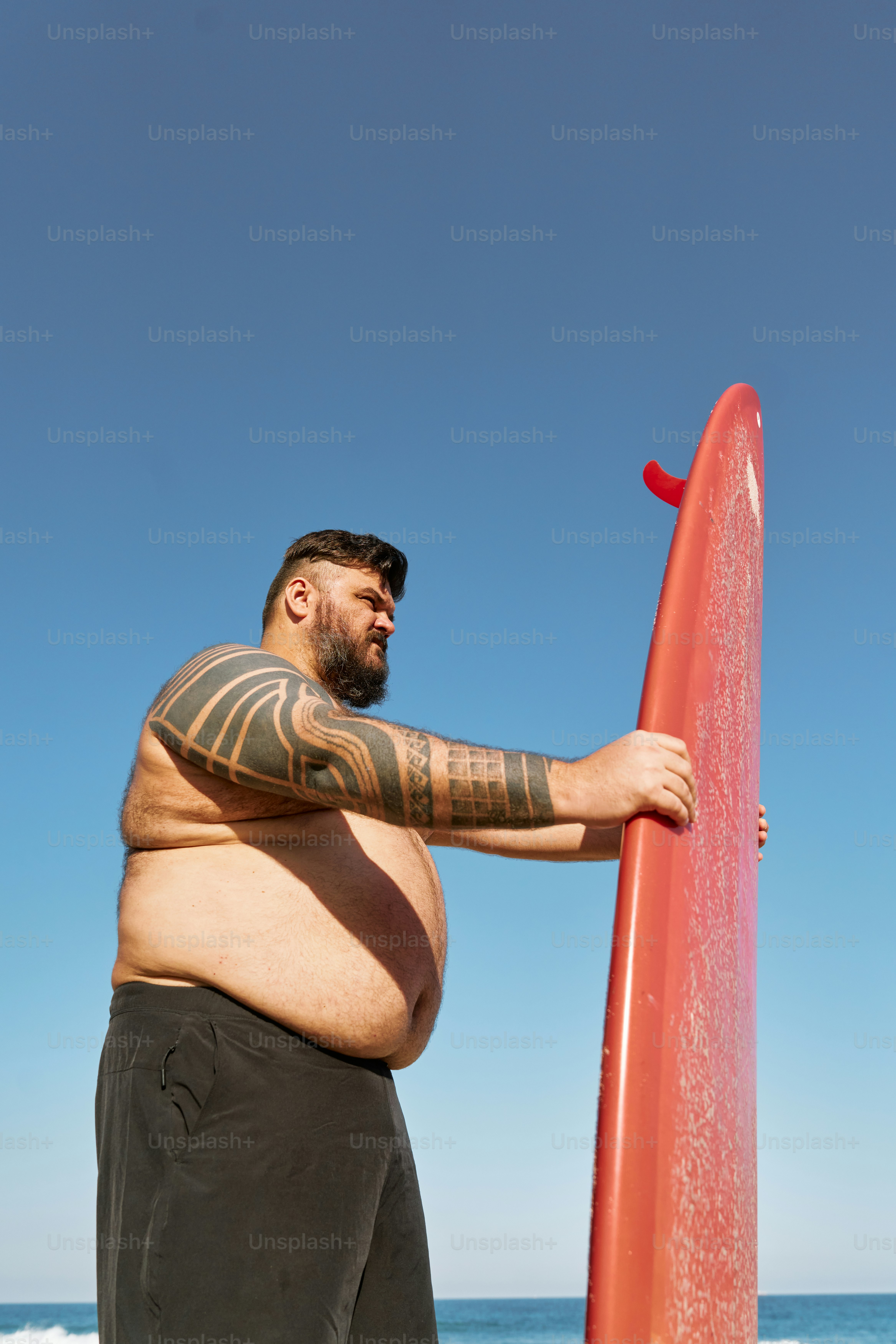 a man holding a surfboard on the beach