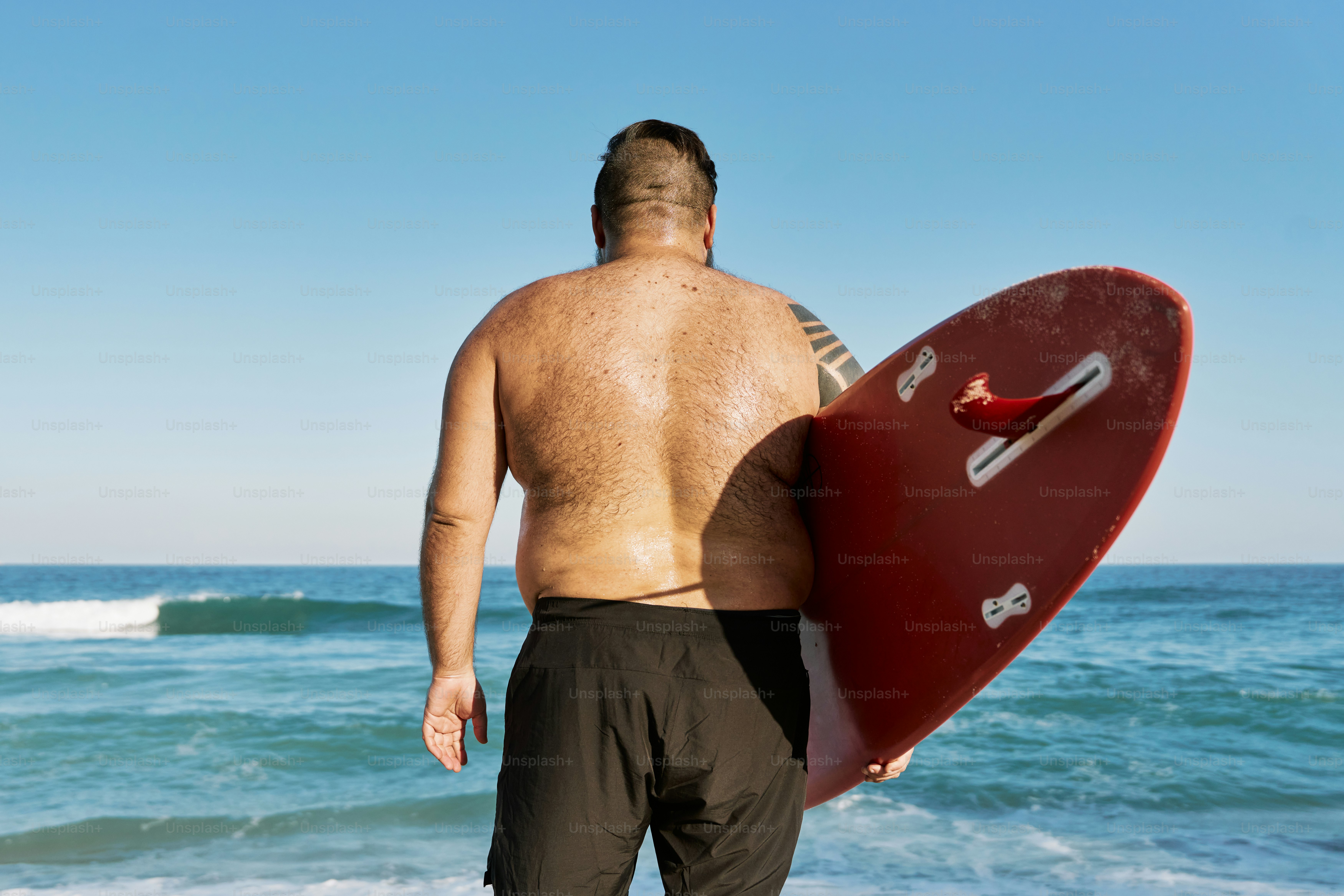a man holding a surfboard on the beach