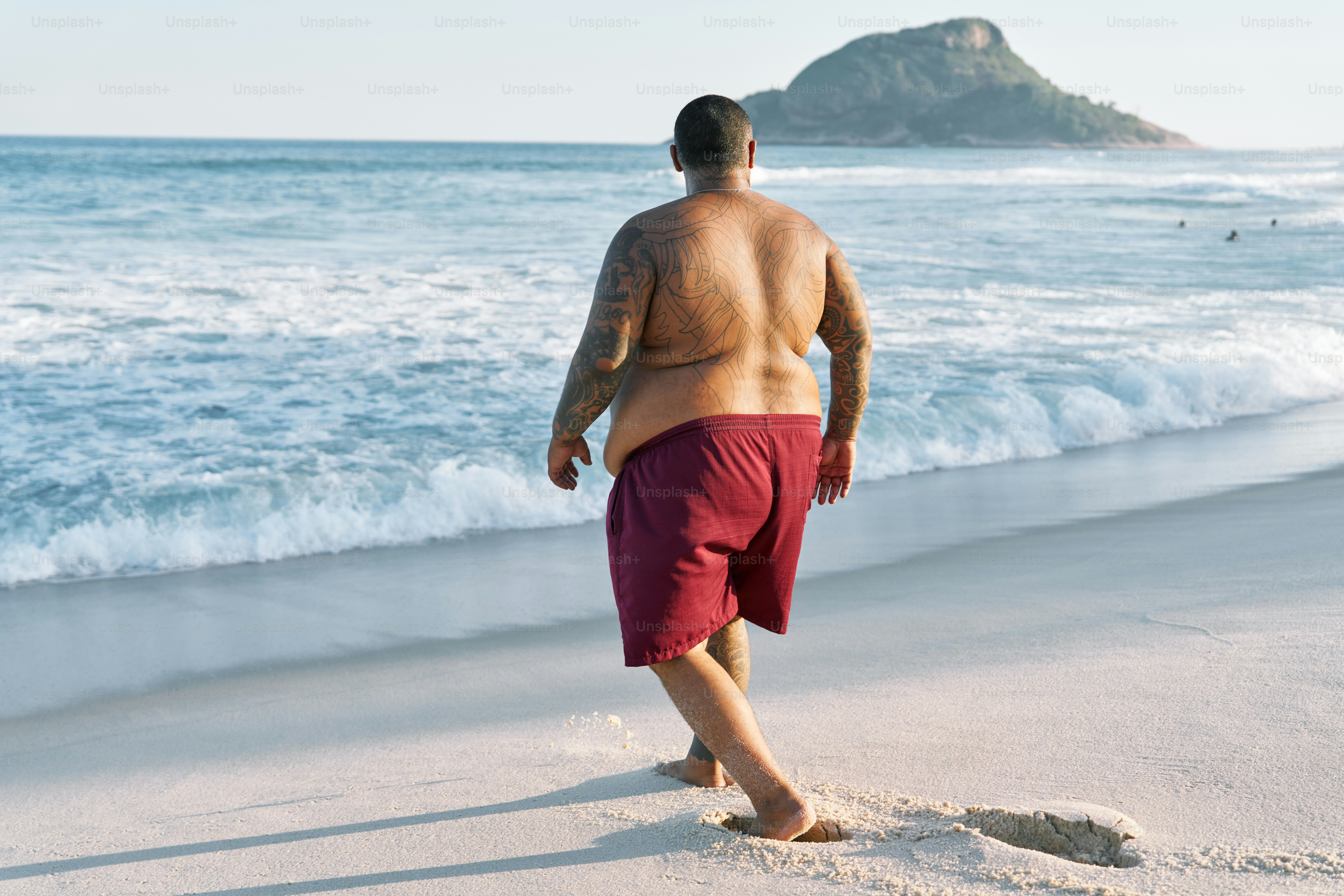 a man walking on a beach next to the ocean