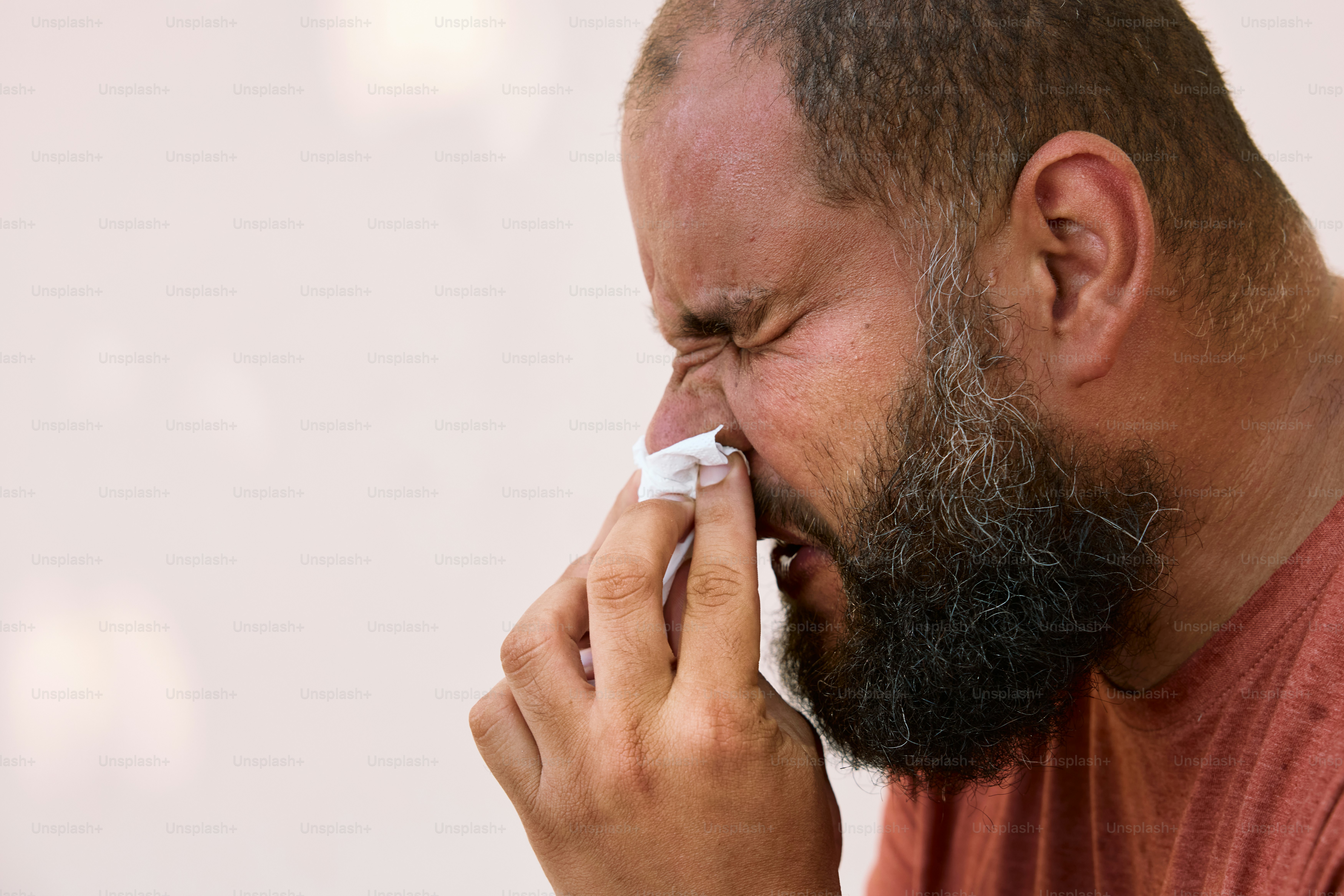 Un homme barbu se mouche