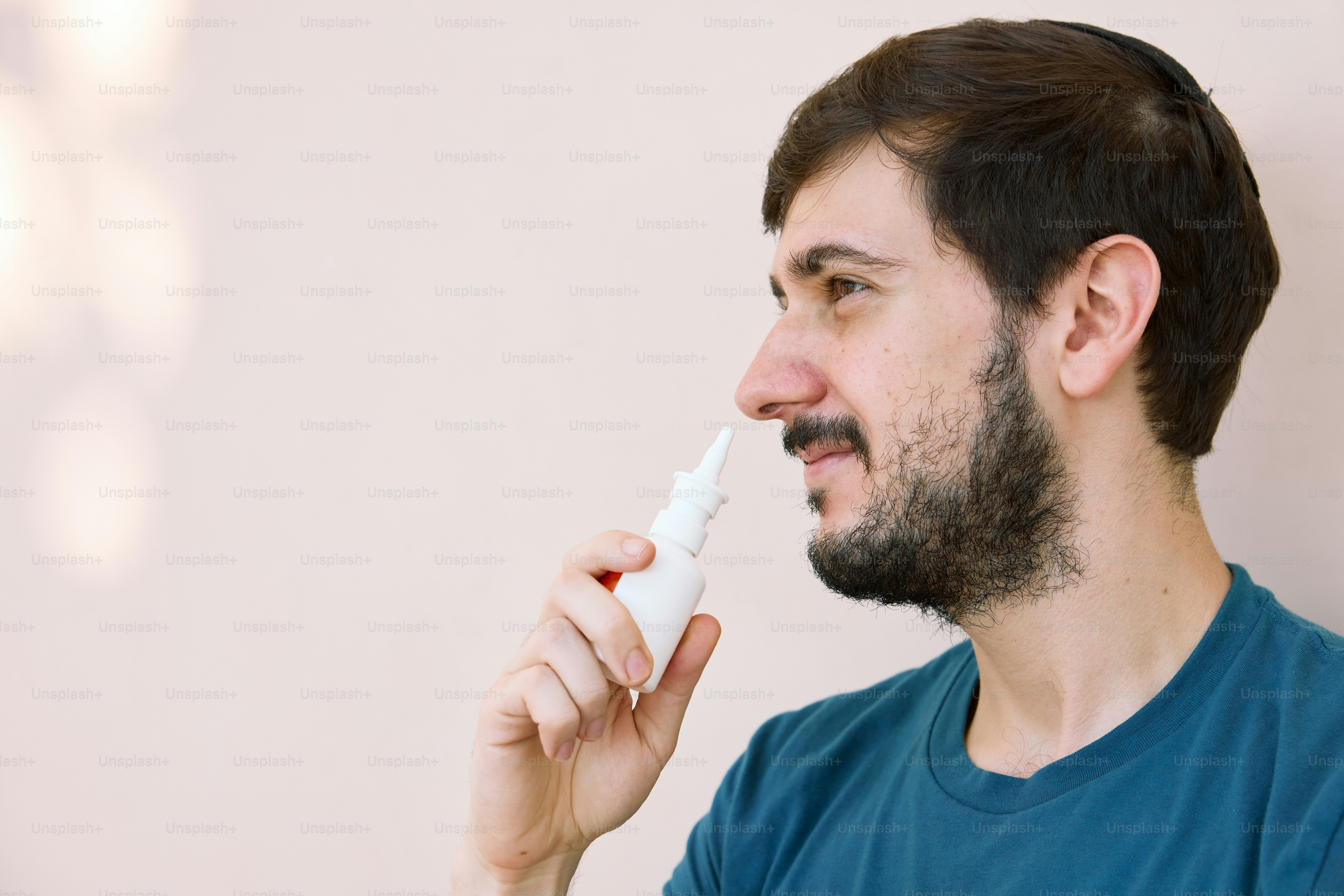 Un hombre con barba está usando un cepillo de dientes eléctrico