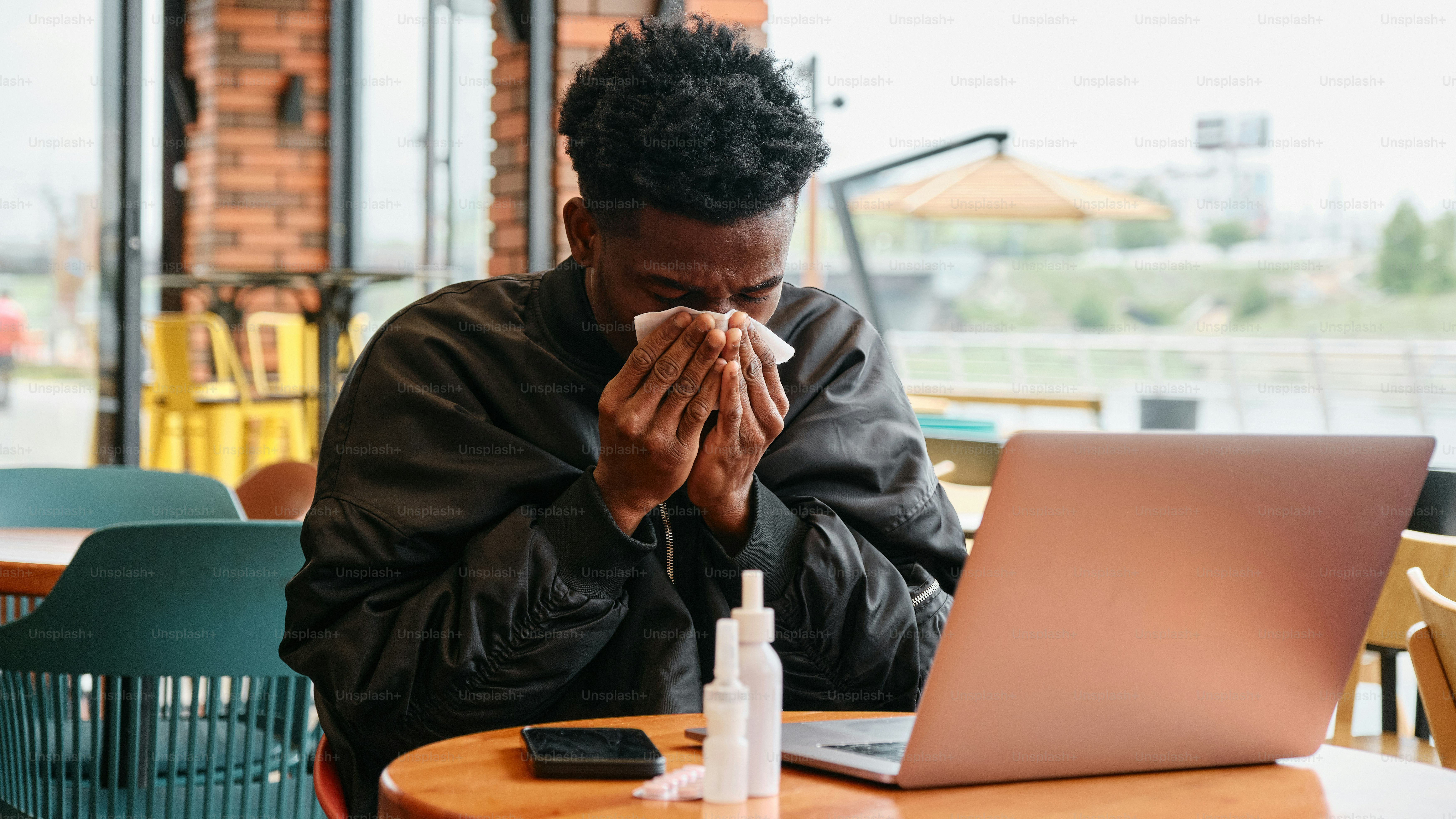 a man sitting at a table in front of a laptop