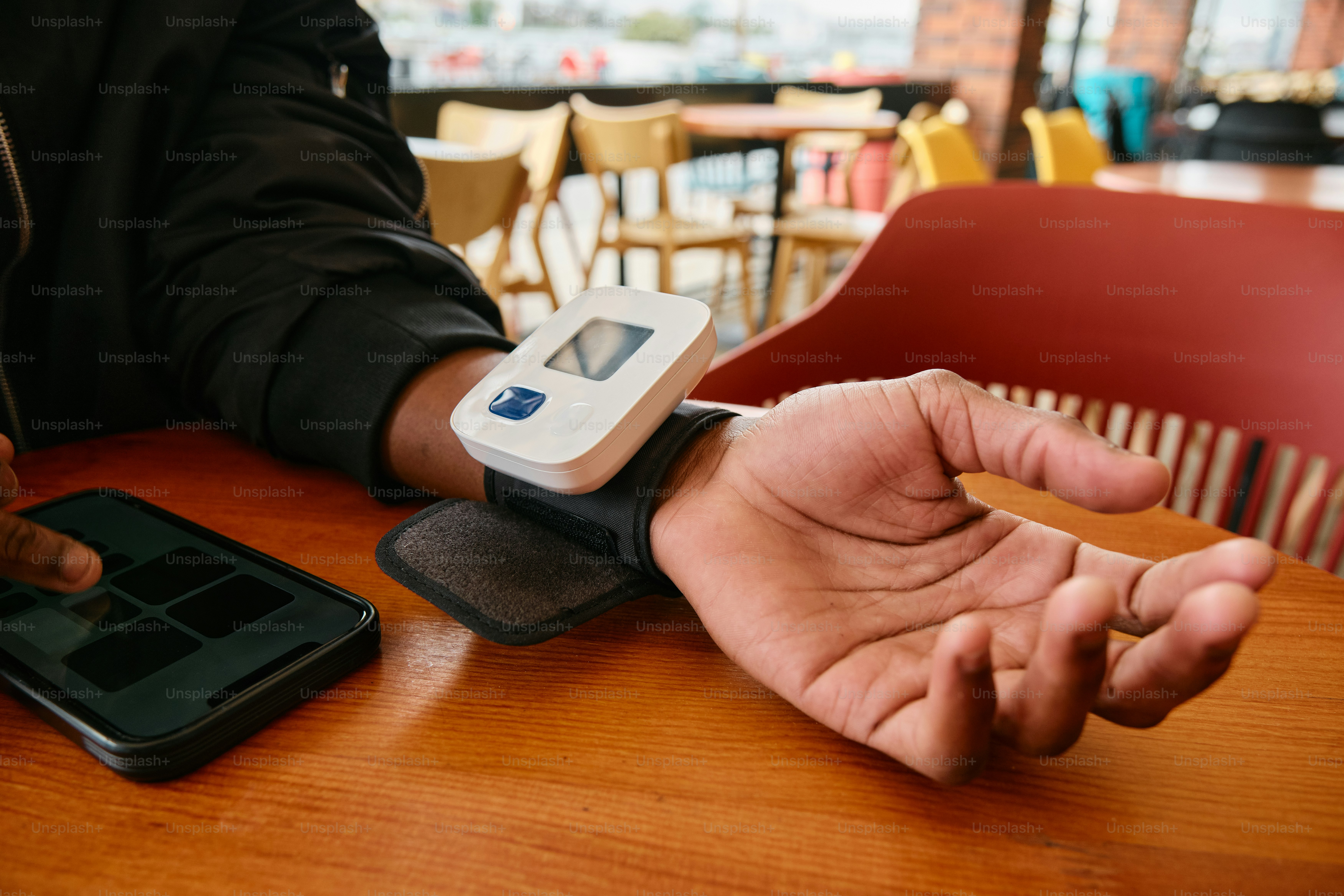una persona seduta a un tavolo con un dispositivo in mano