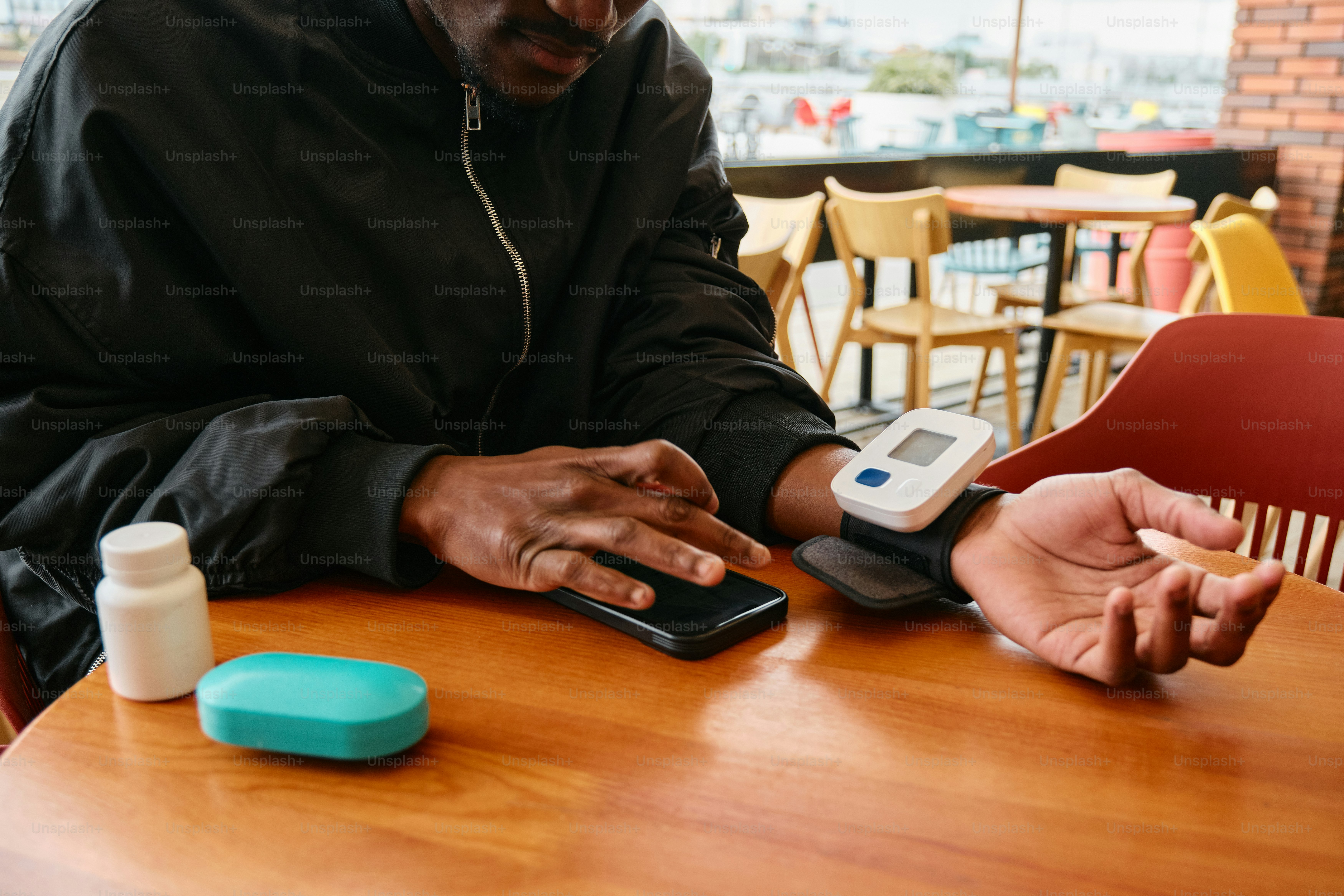 Un hombre sentado en una mesa con un teléfono celular