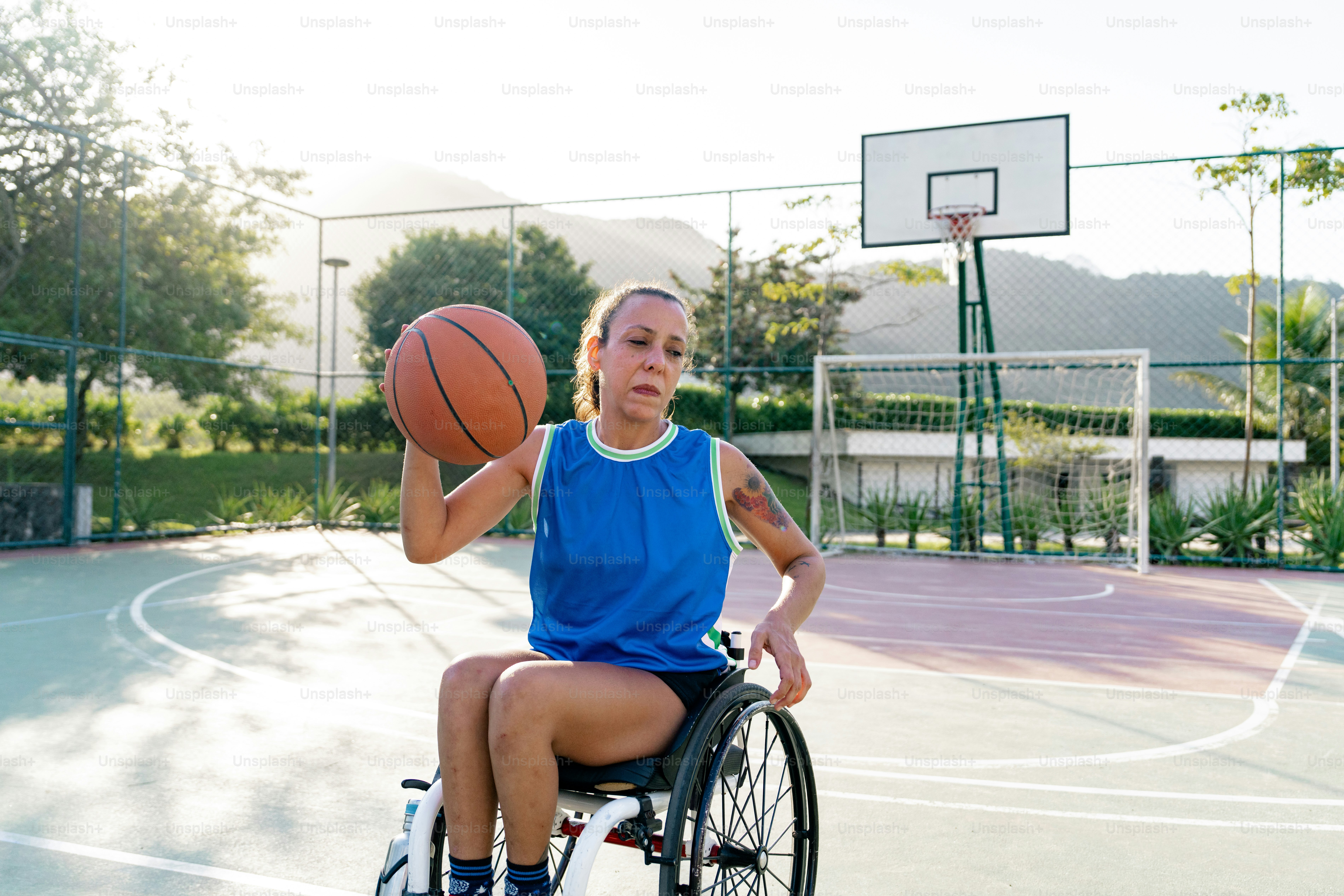 A woman in a wheel chair holding a basketball photo – Disability Image ...