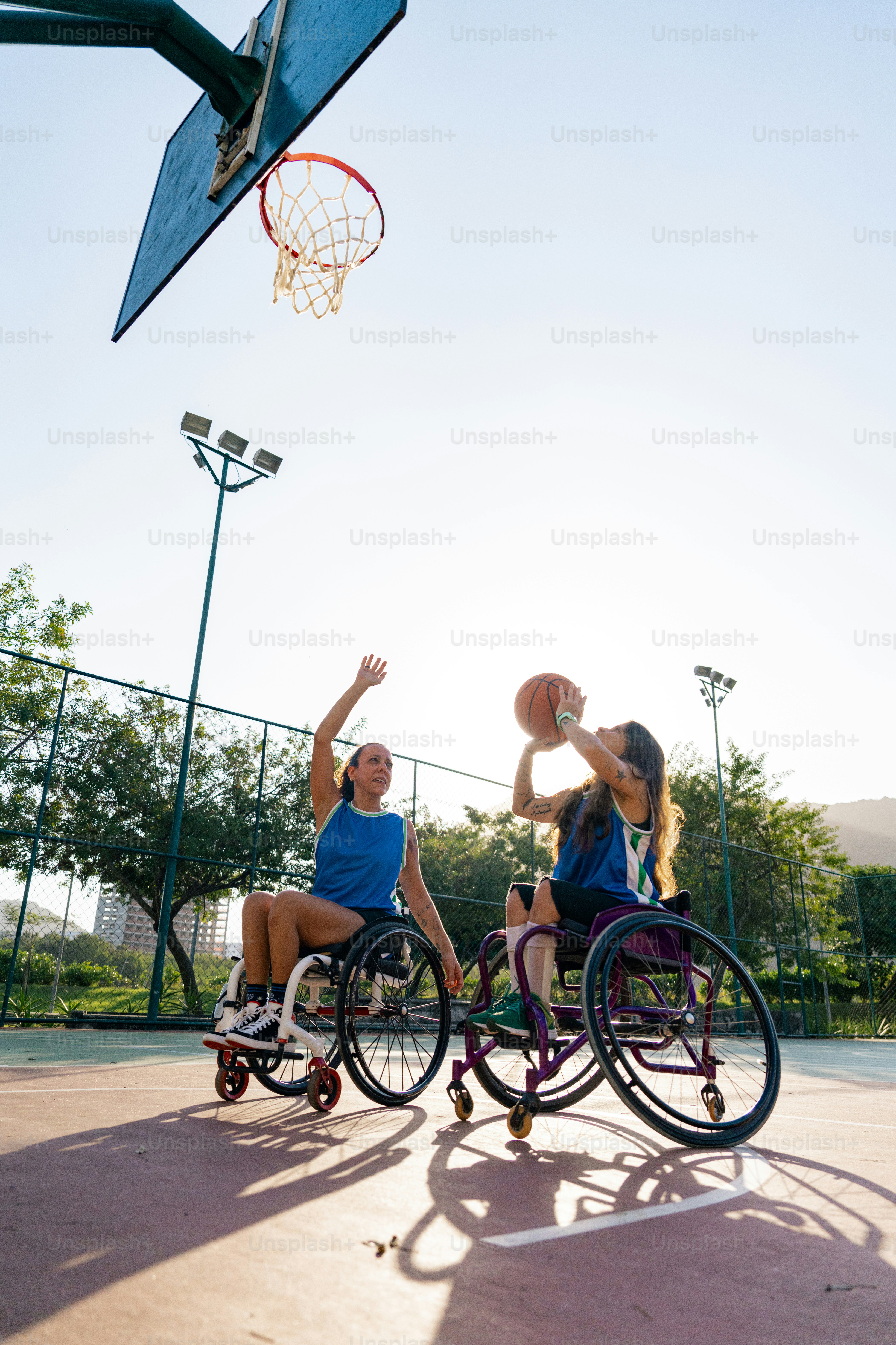 Dos personas en sillas de ruedas jugando al baloncesto en una cancha