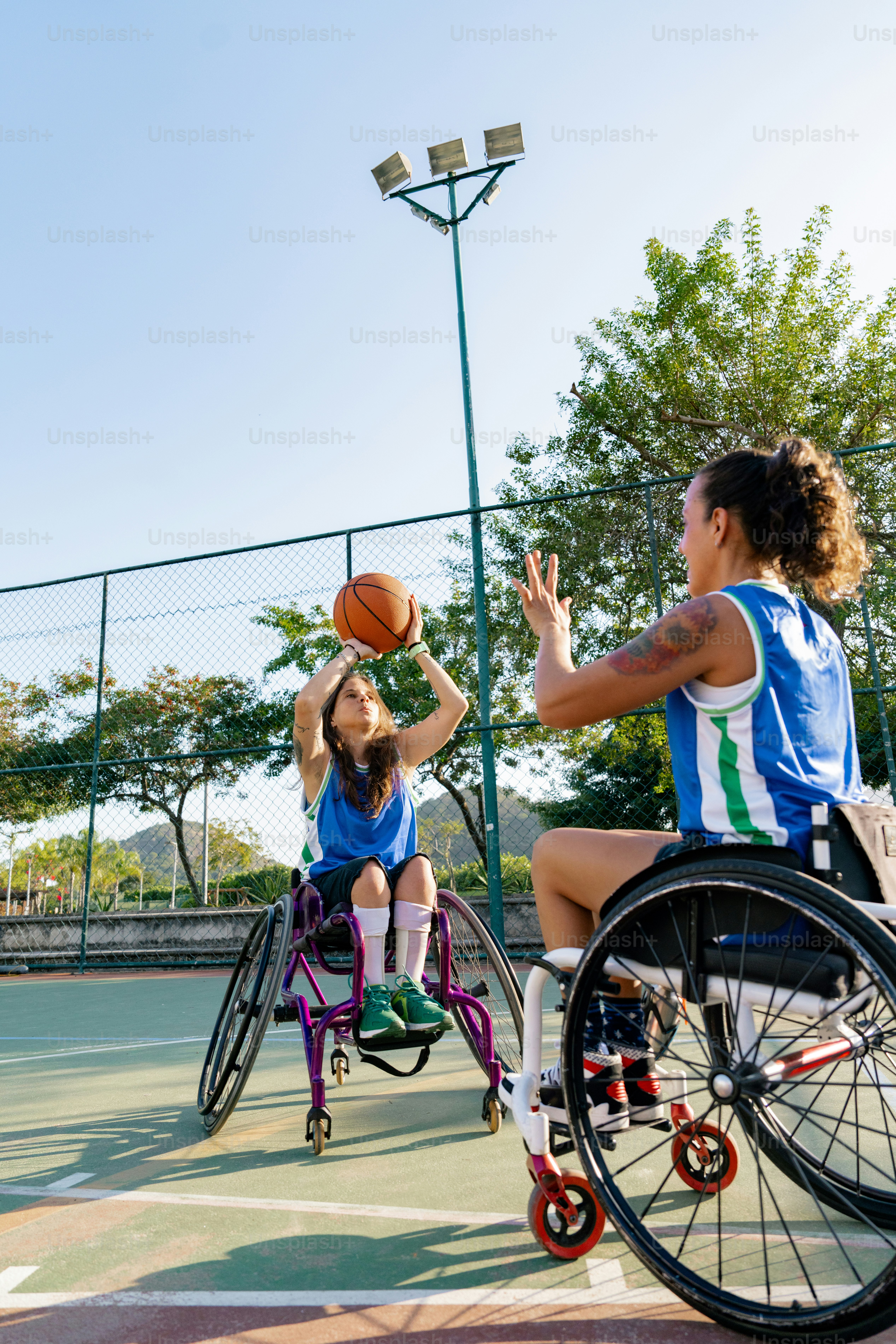 una mujer en silla de ruedas jugando al baloncesto con una niña