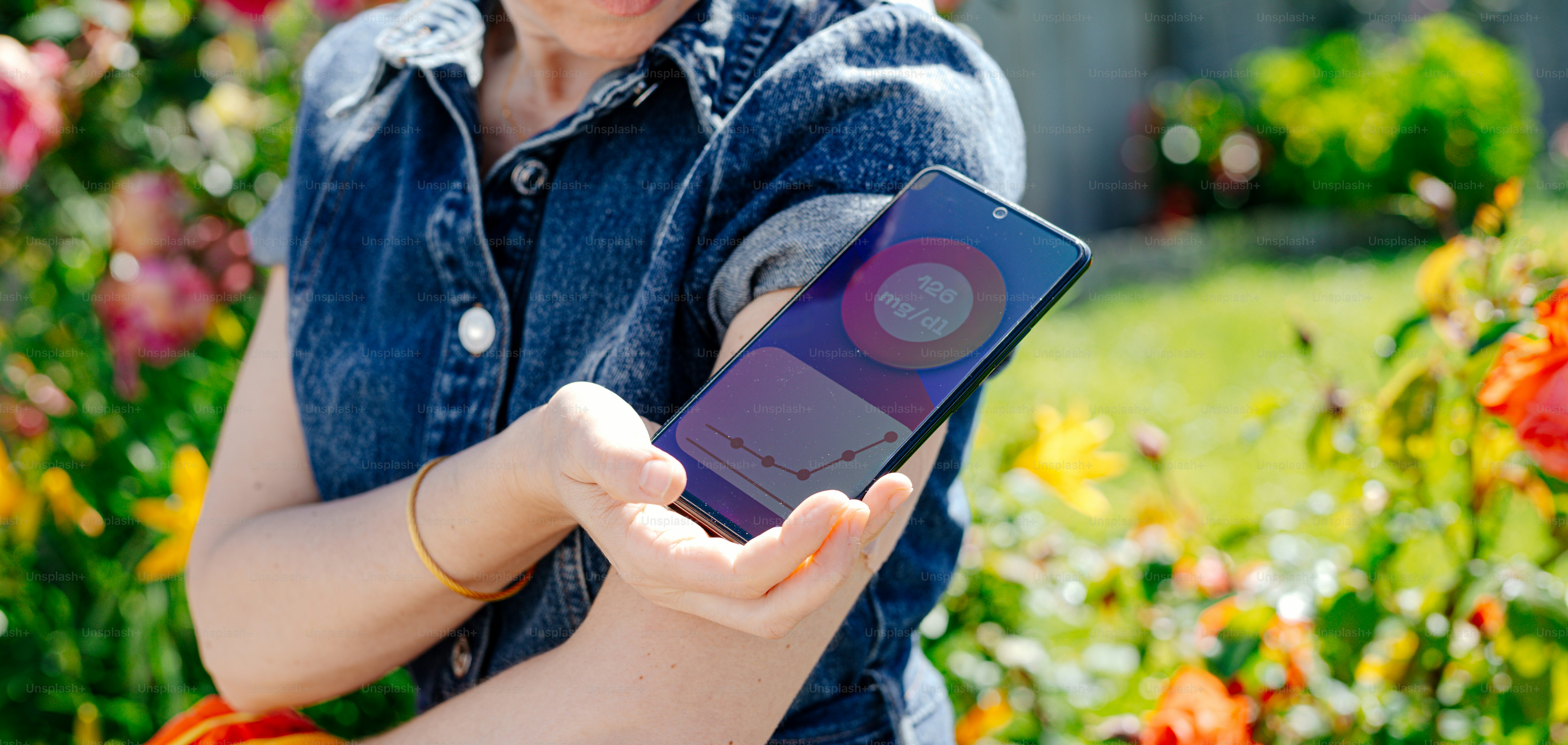 Una mujer sosteniendo un teléfono celular en sus manos