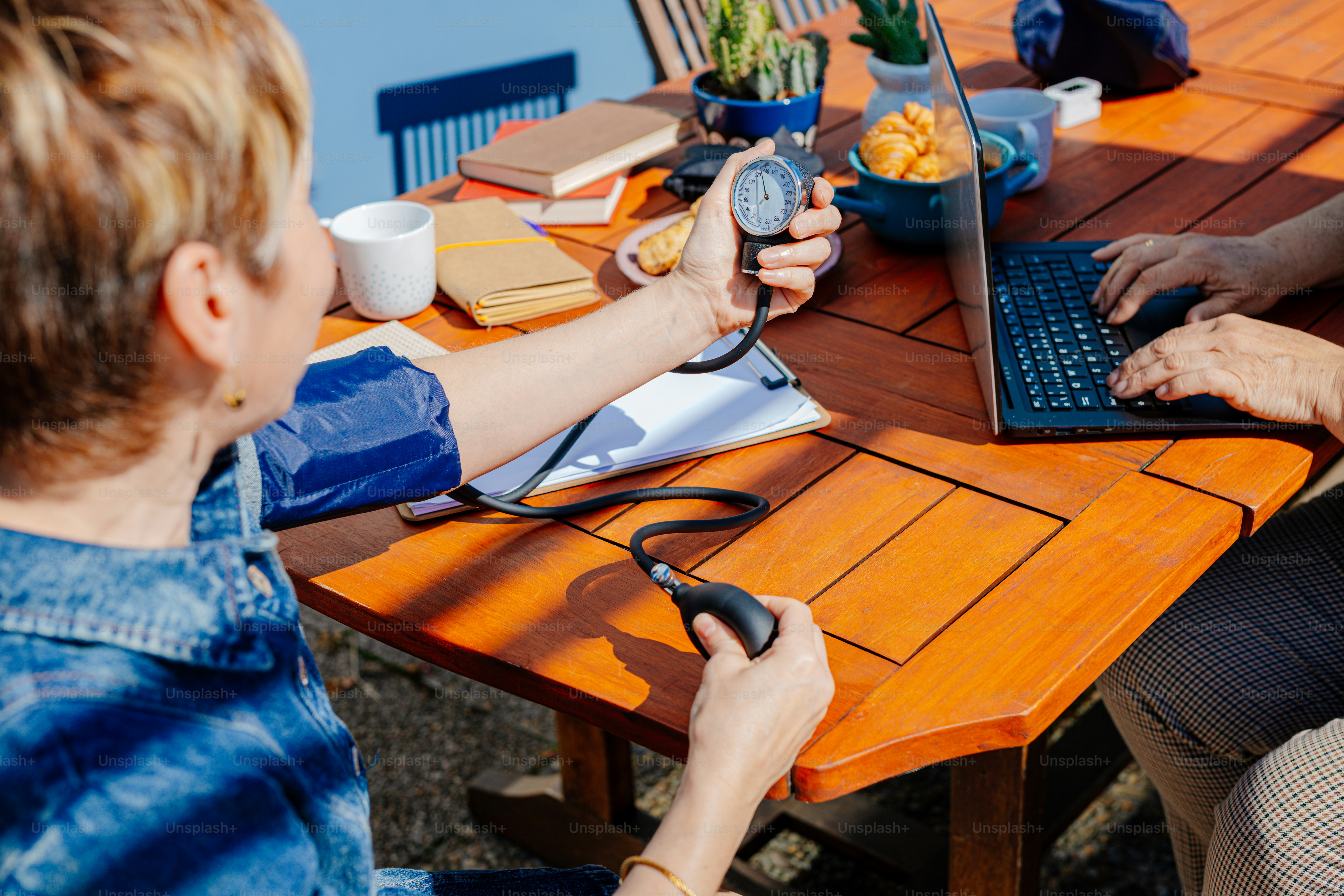 Un par de personas sentadas en una mesa con un ordenador portátil