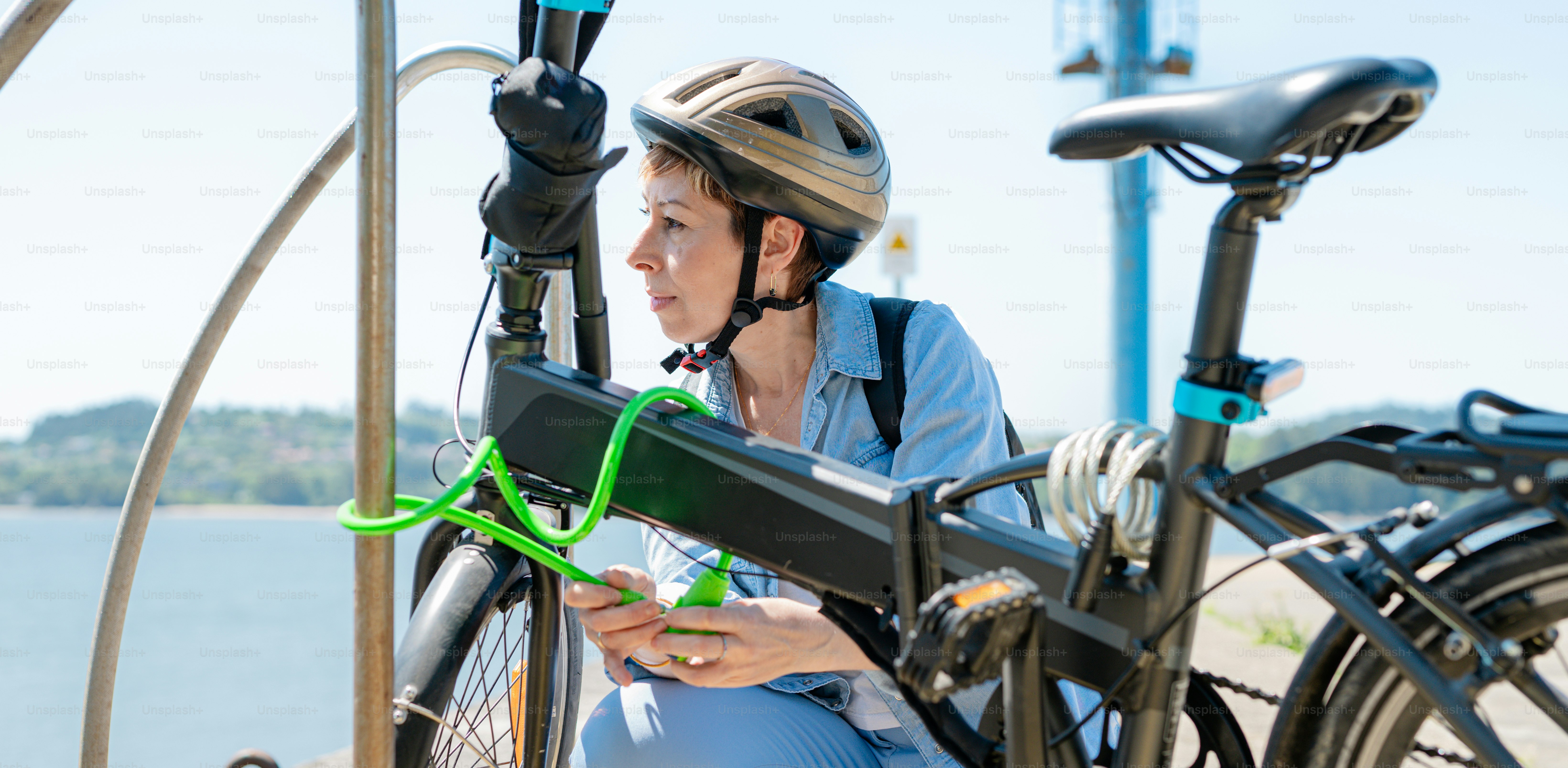 a woman sitting next to a bike with a green handlebar