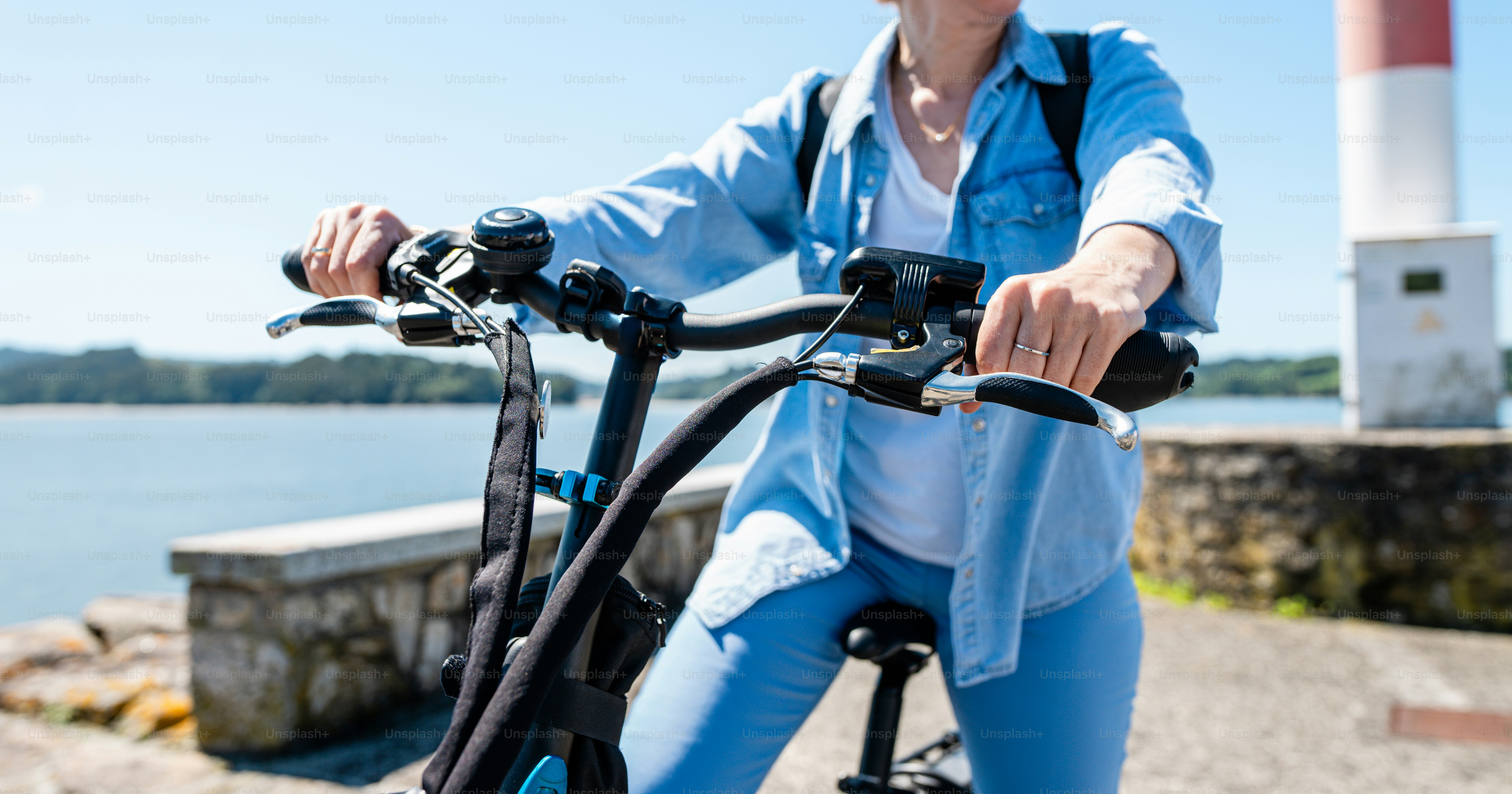 a woman riding a bike next to a body of water