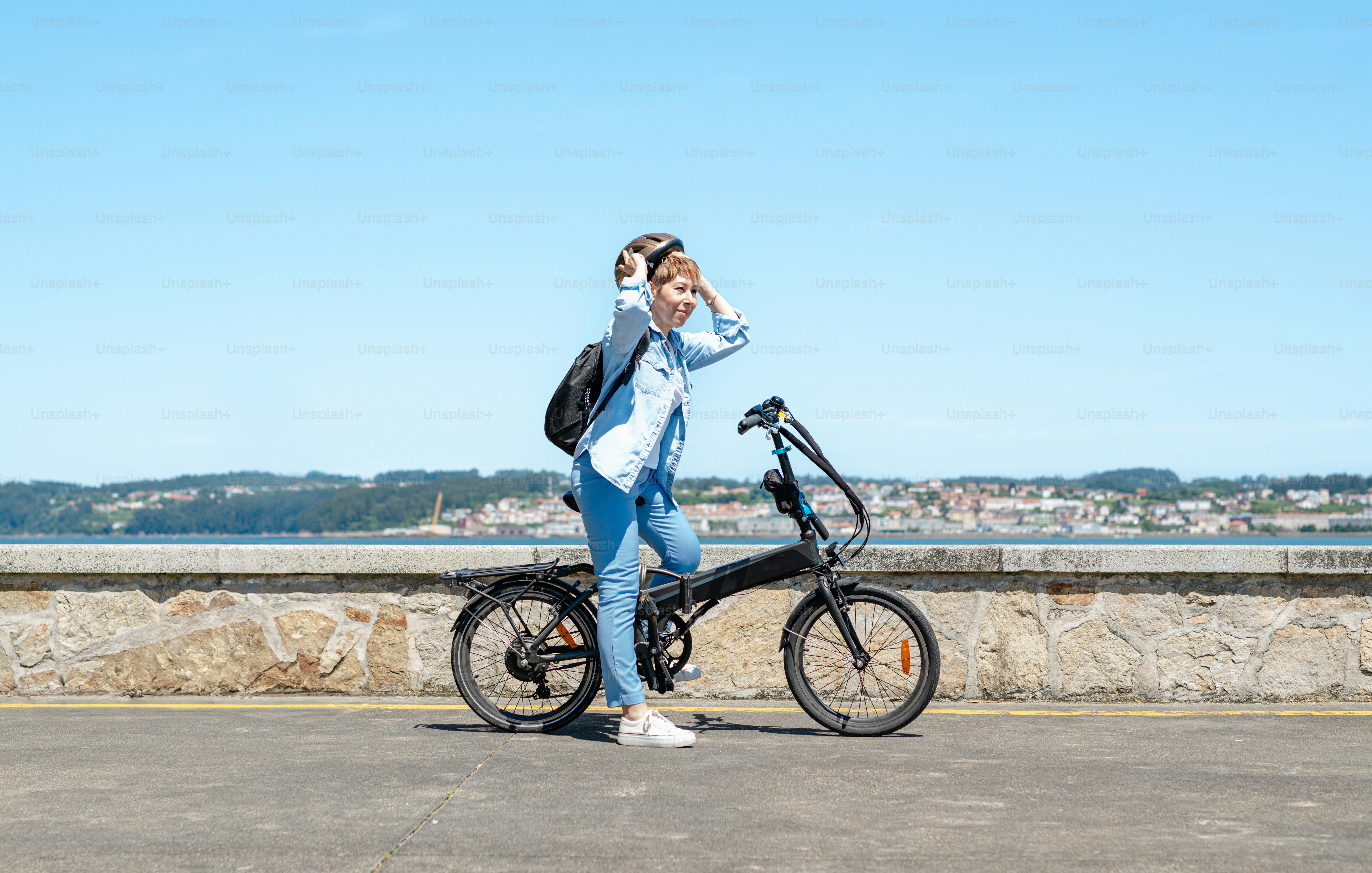 a woman standing next to a black bike