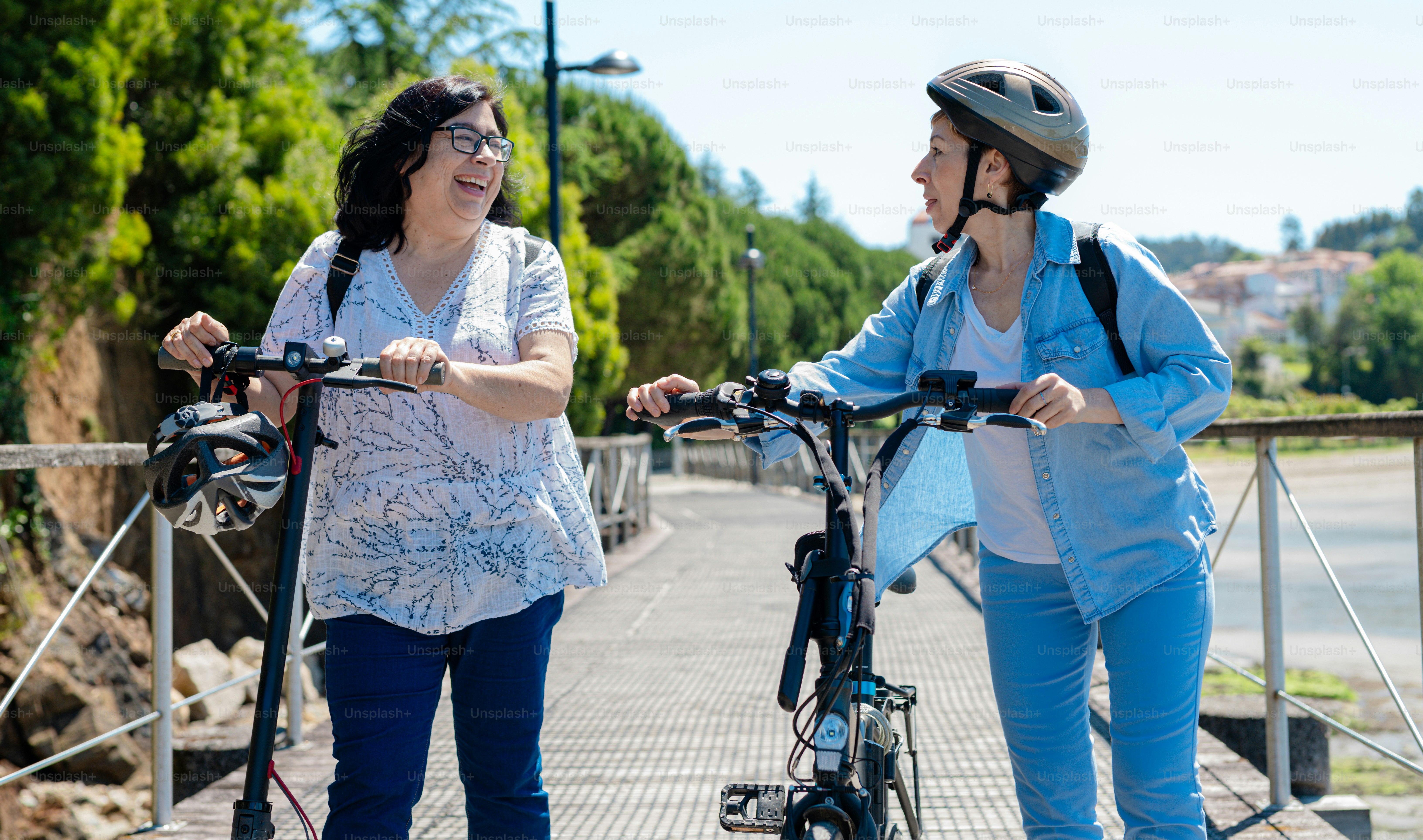 a couple of women standing next to each other on bicycles