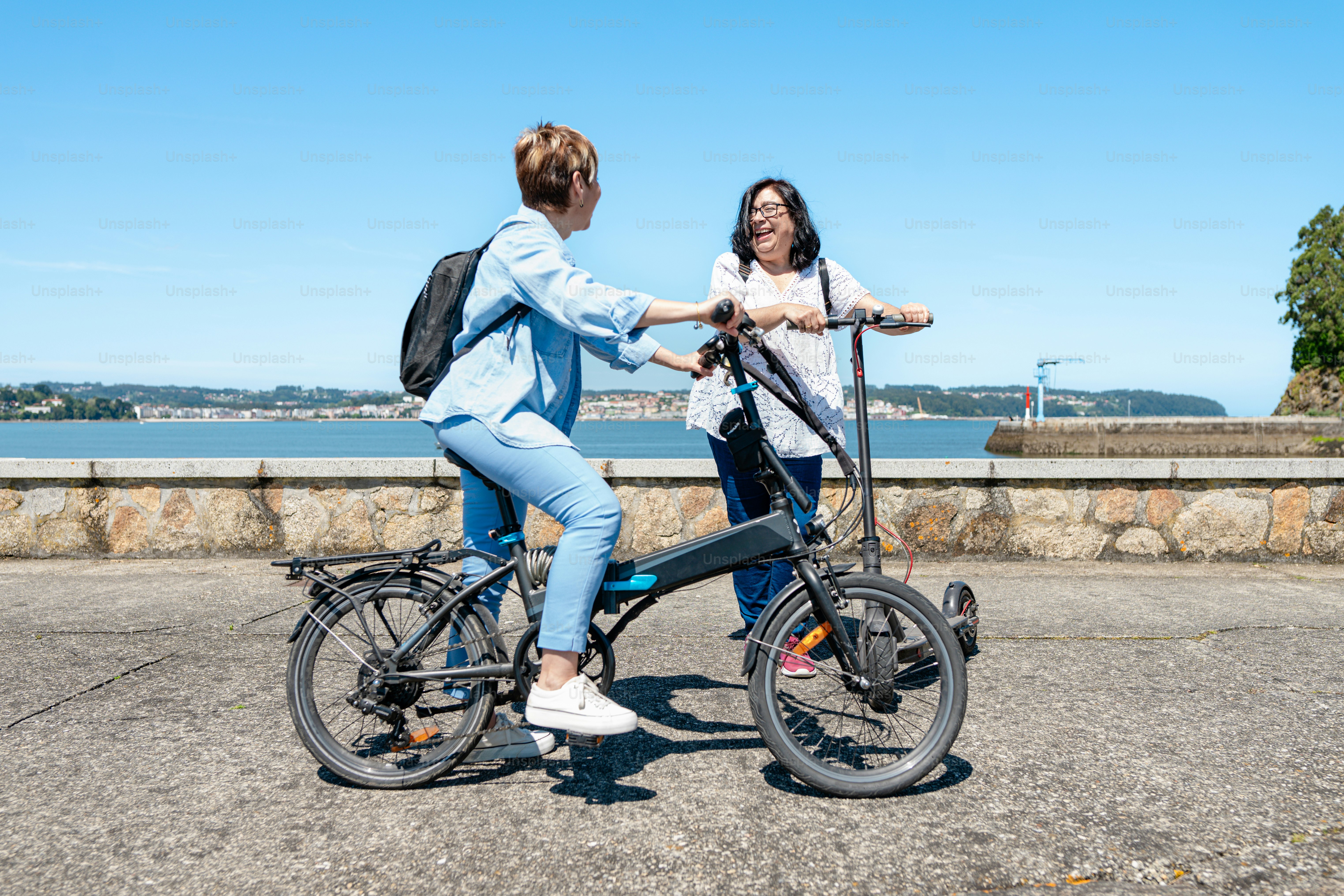 due donne in piedi l'una accanto all'altra su una bicicletta