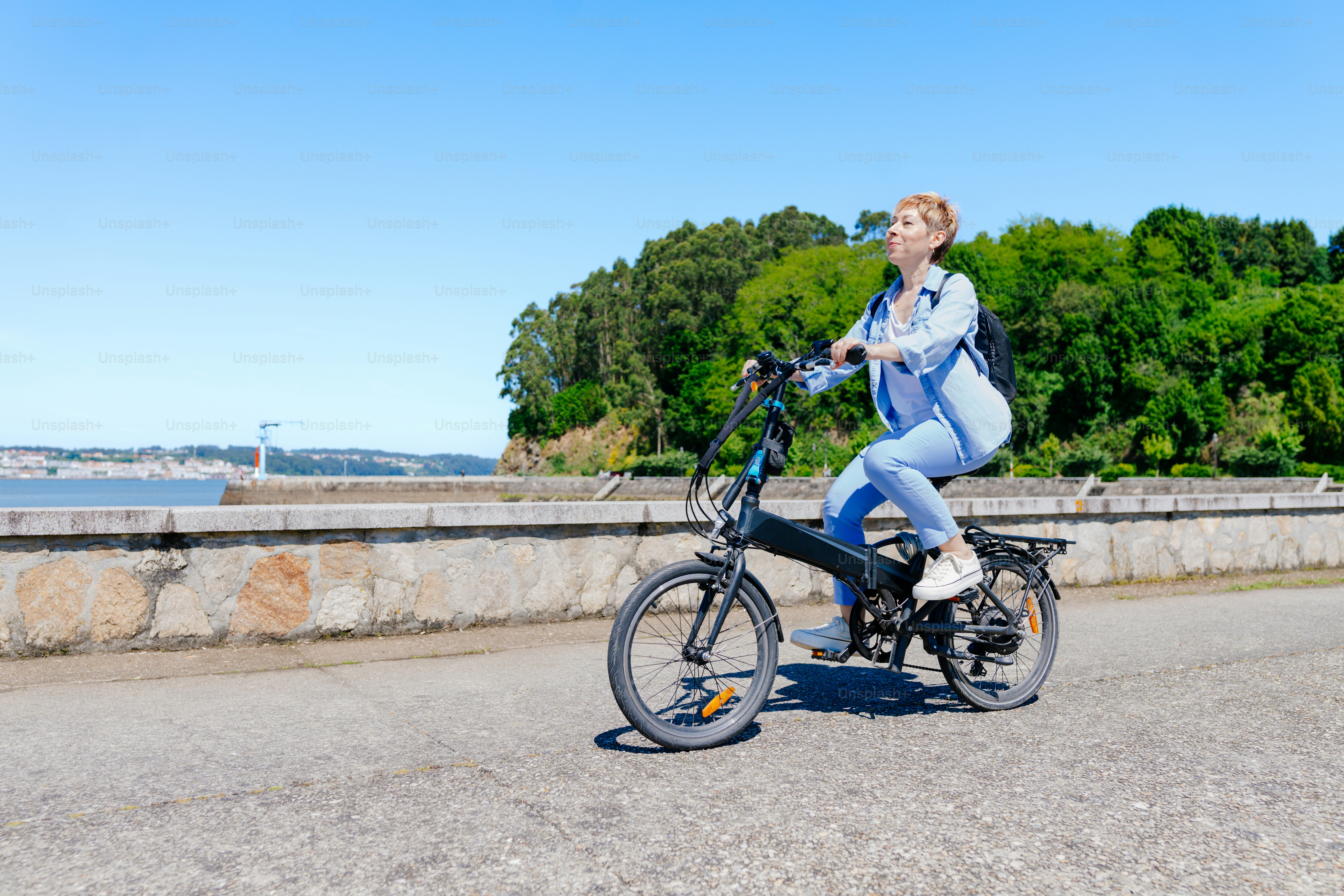 a woman riding a bike down a street