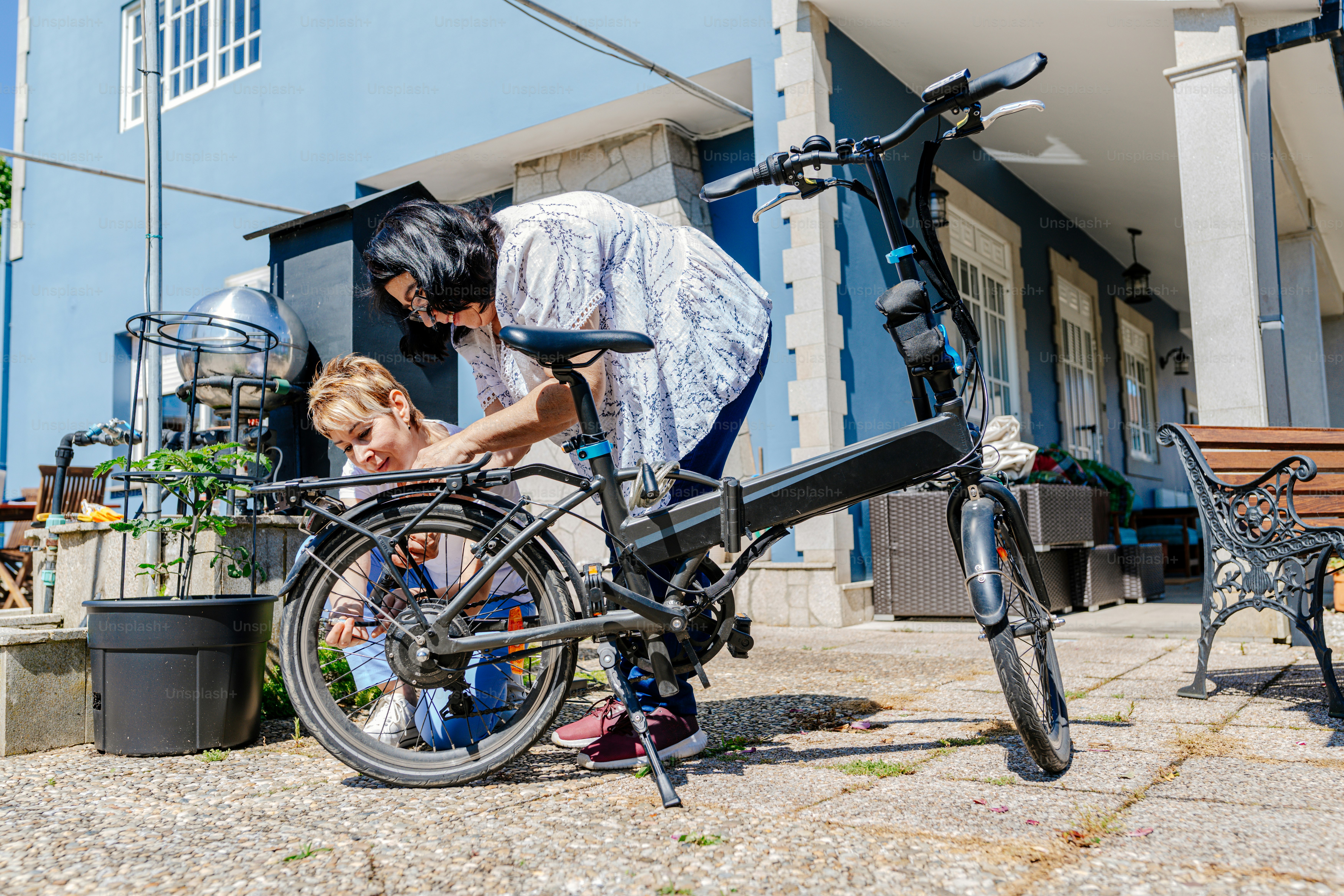 a woman standing next to a child on a bike