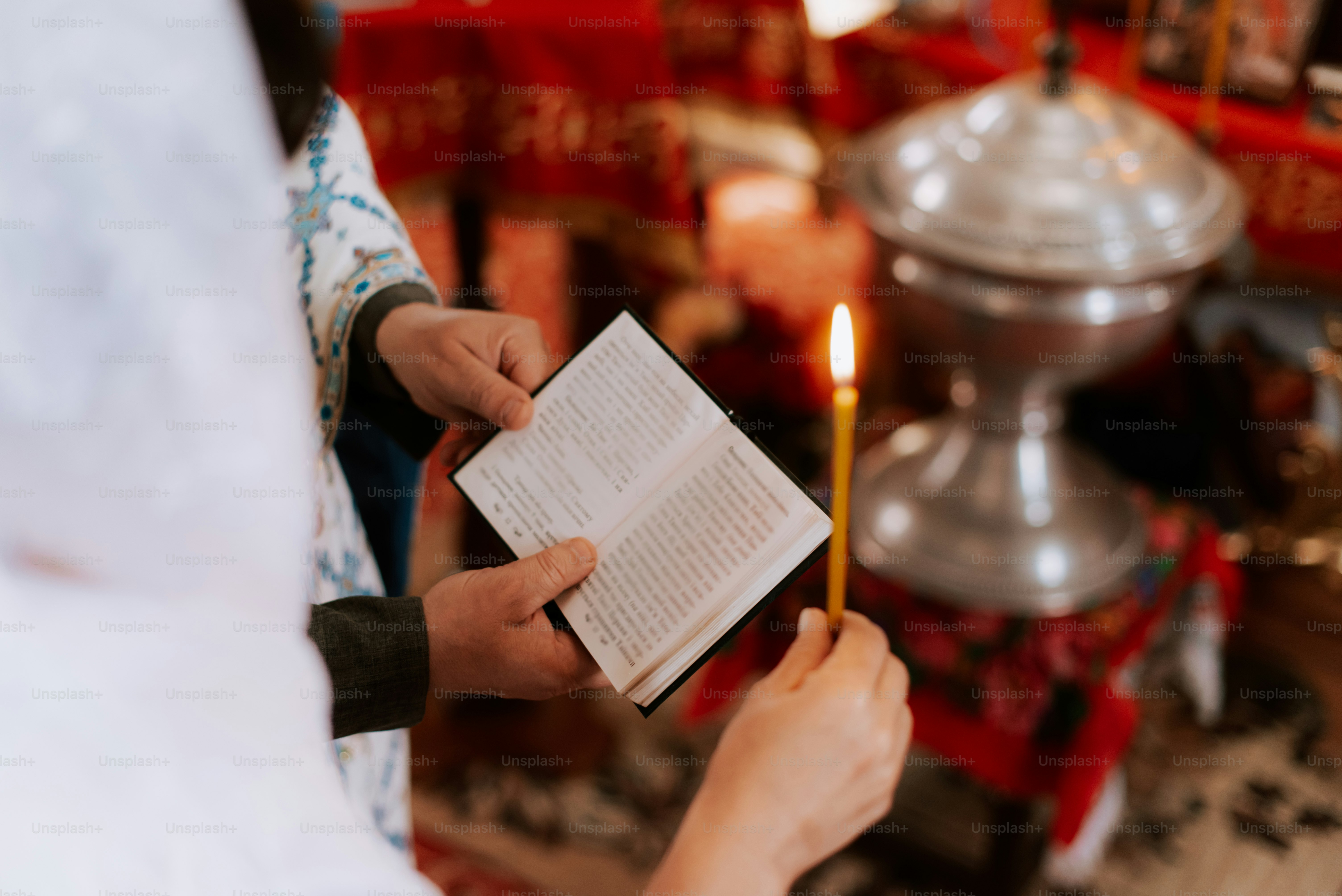 a person holding a book and a candle