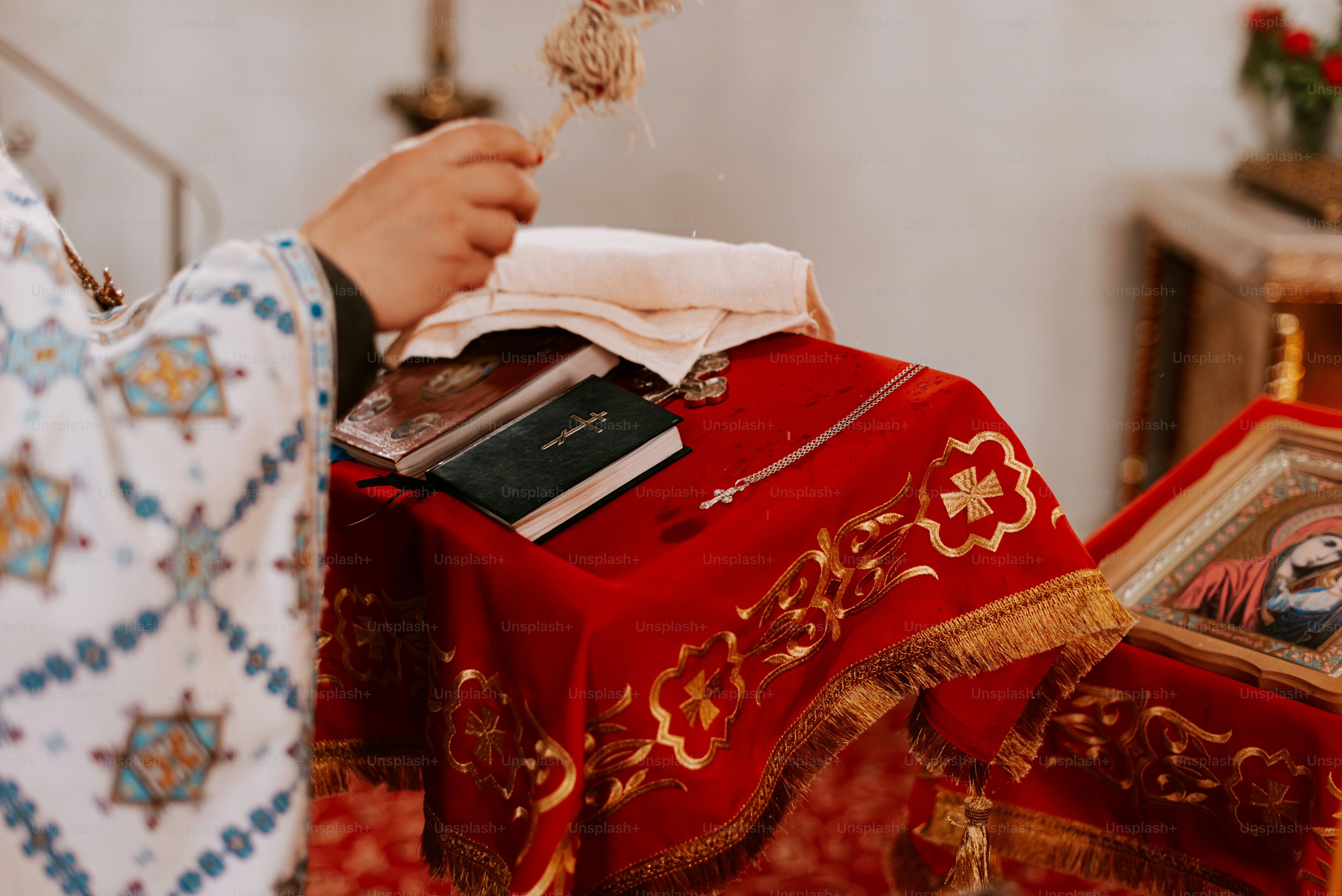 Ein Priester hält ein Tuch und ein Kreuz in der Hand