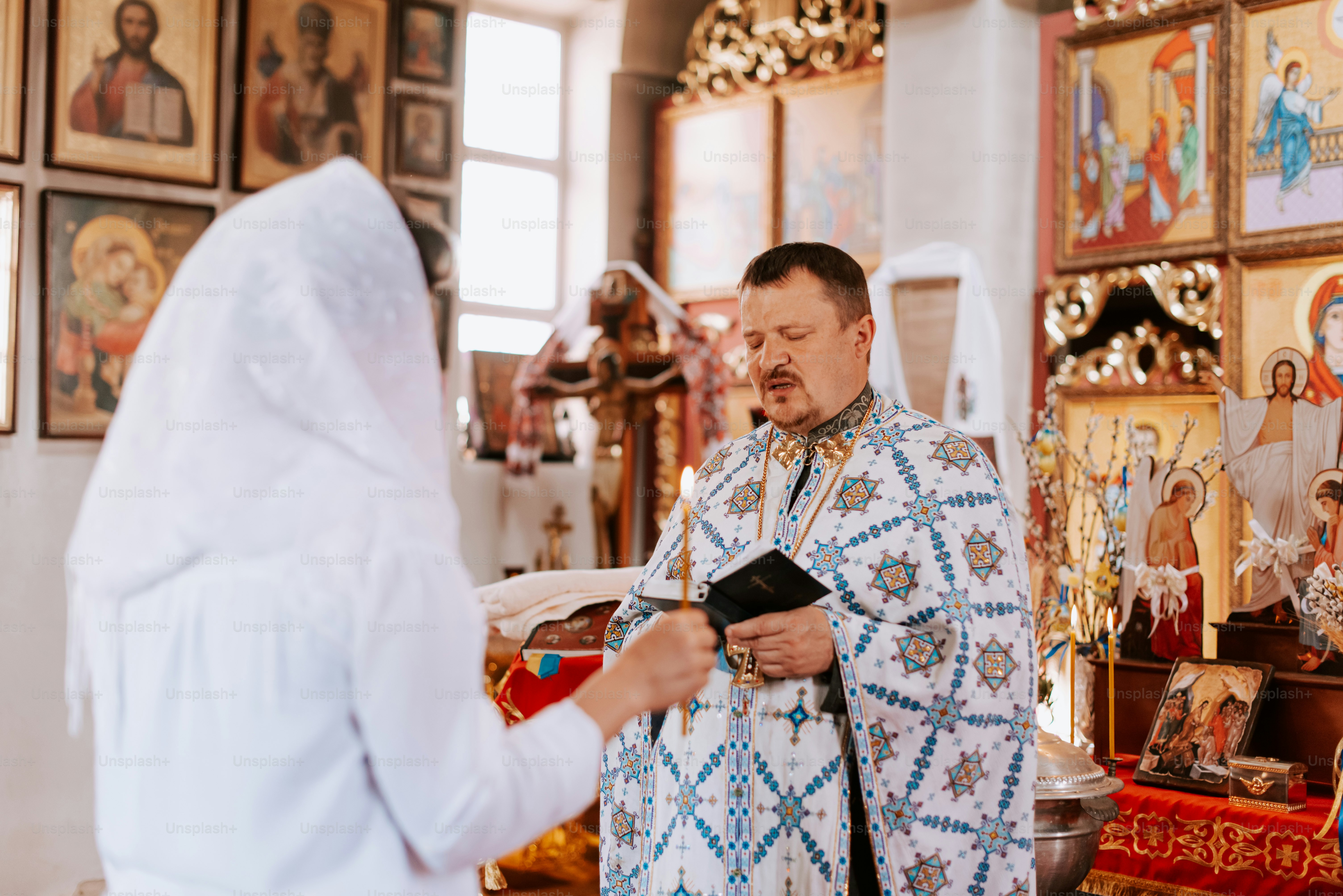 a man in a priest's outfit standing next to a woman