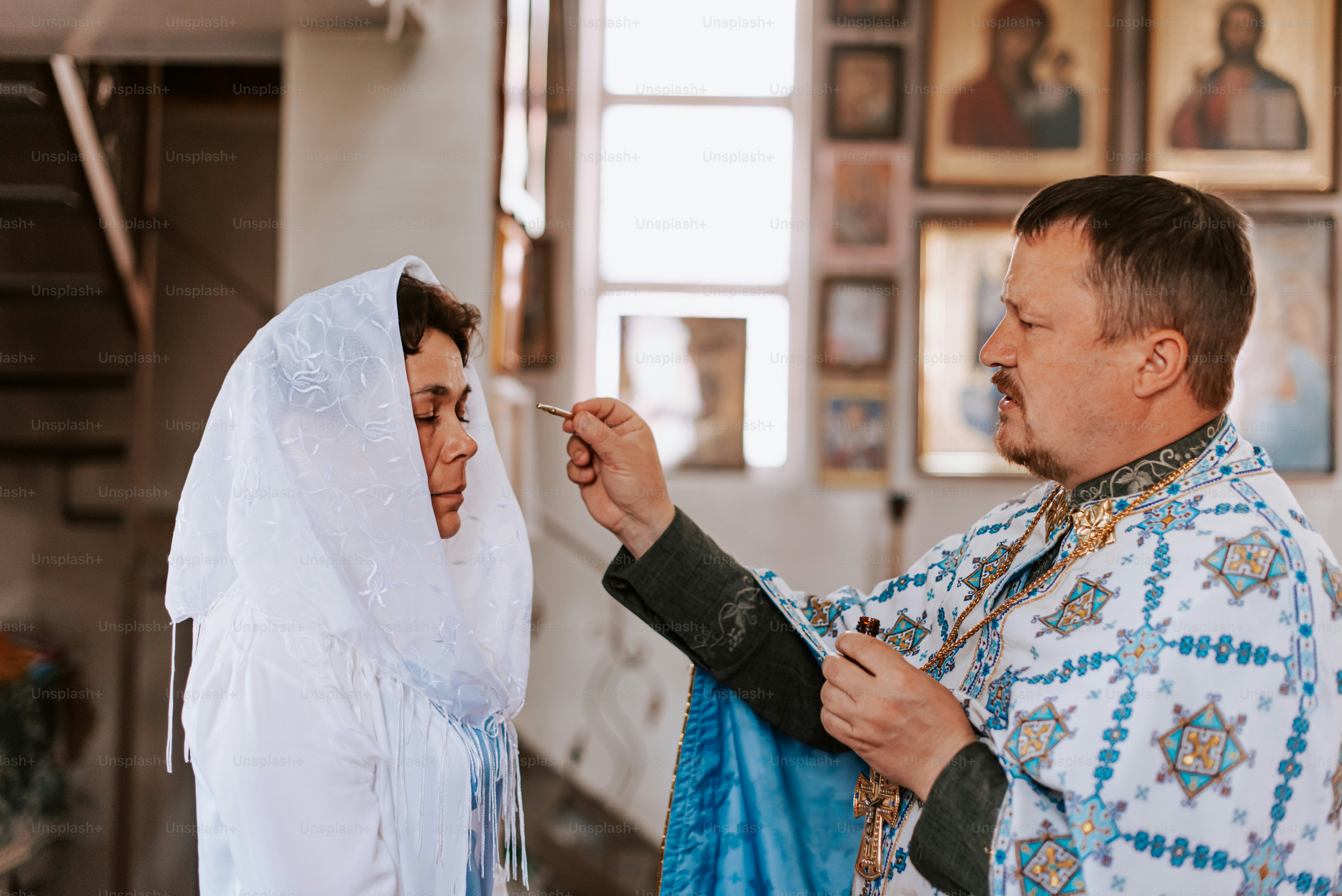 a man in a priest's outfit is putting a cigarette in a woman '