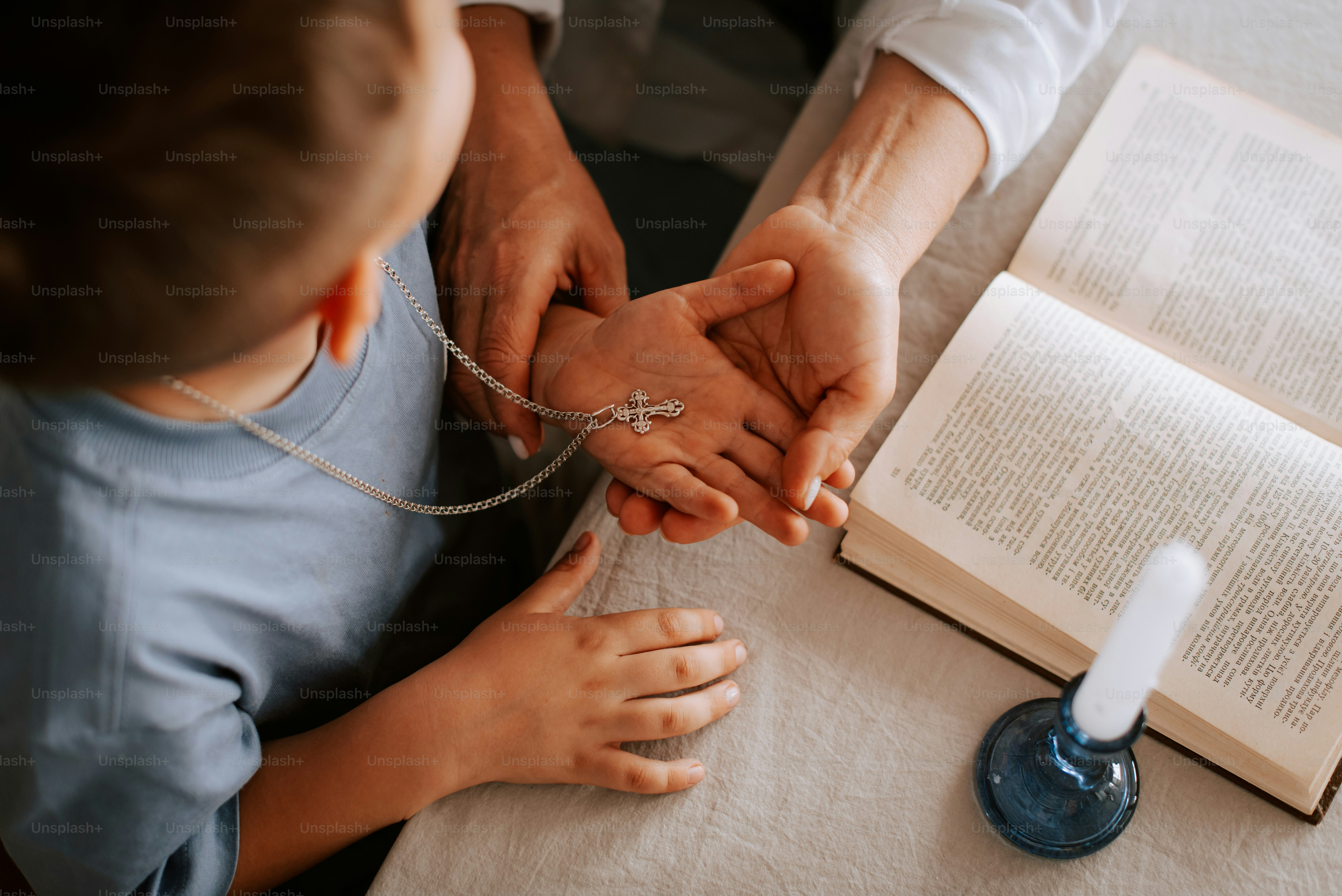 a man and a child holding hands over an open book