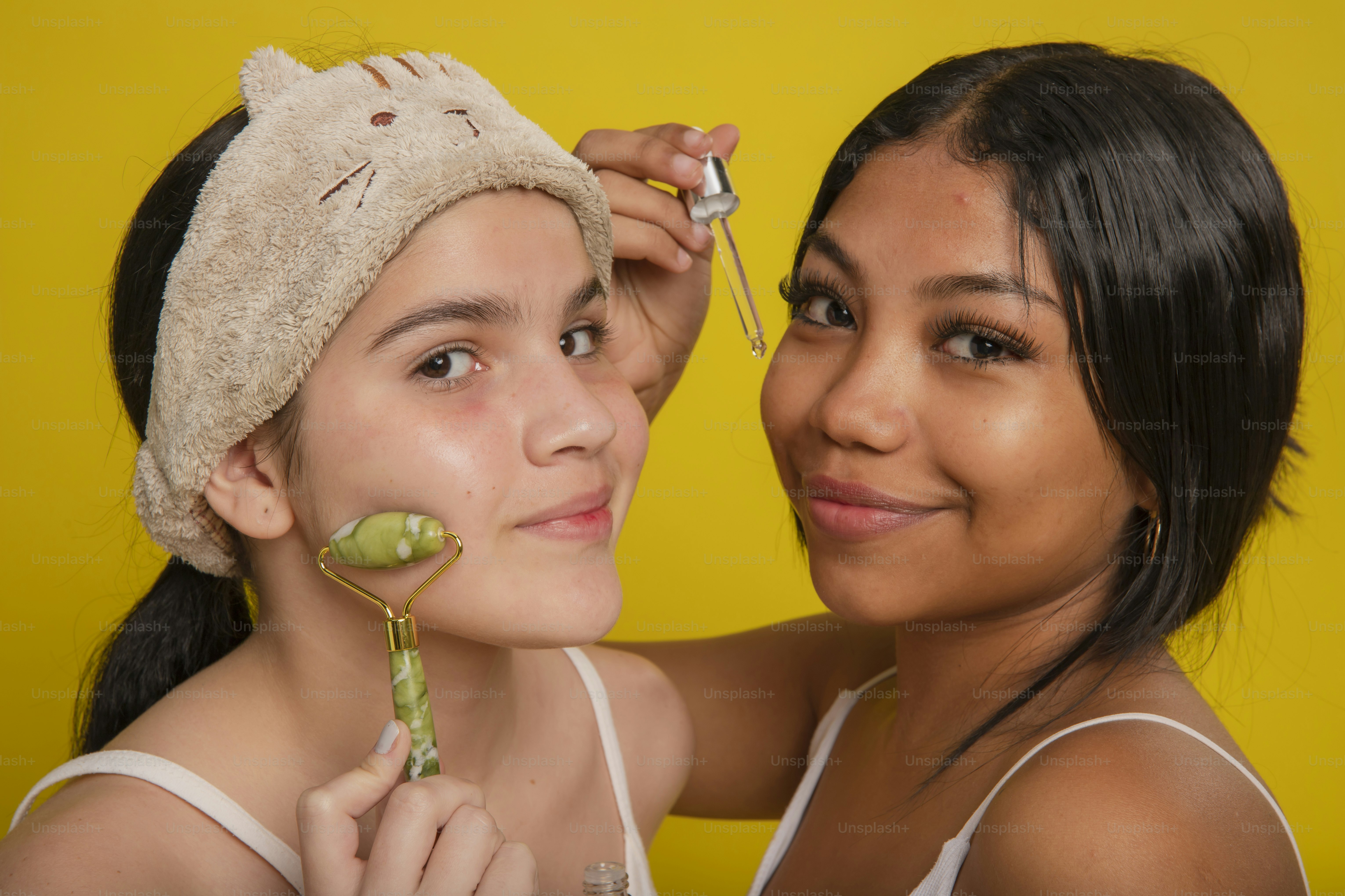 Eine Frau hält eine Blume neben einem Mädchen mit einem Handtuch auf dem Kopf